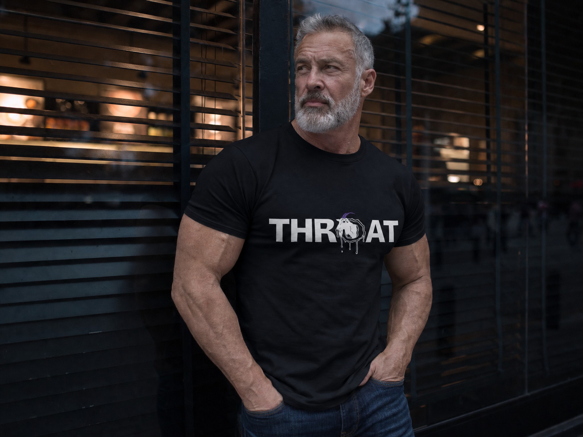 Mature, muscular man with a silver beard wearing the Black THROAT Goat tee