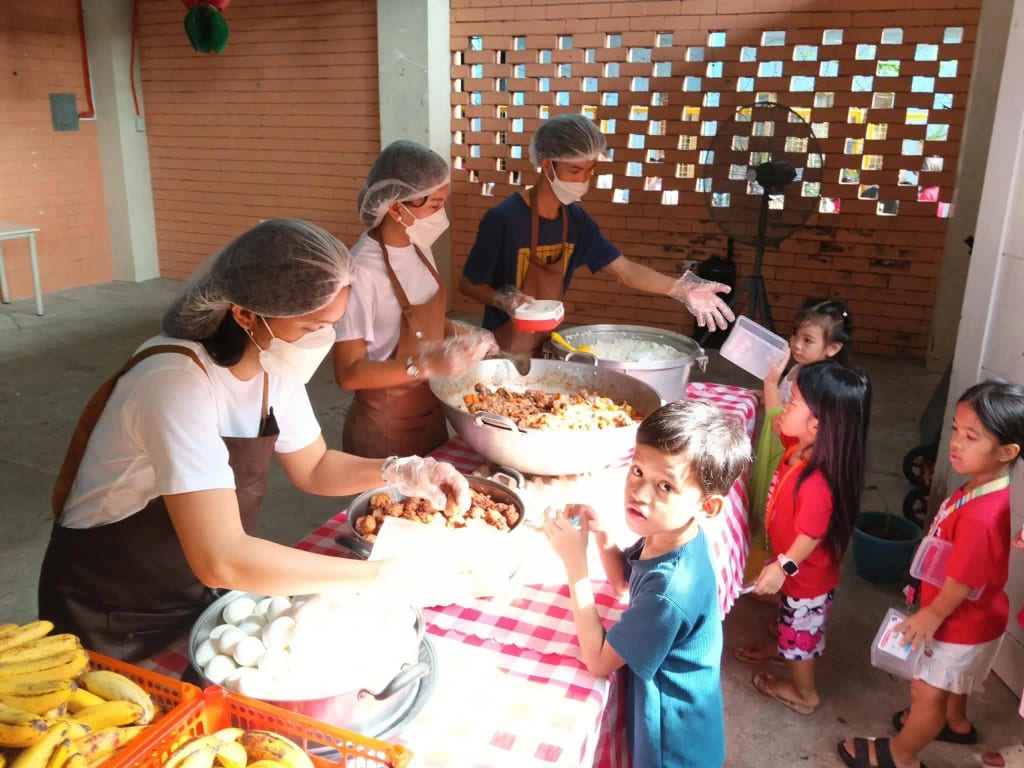 Project PEARLS team preparing a meal for children