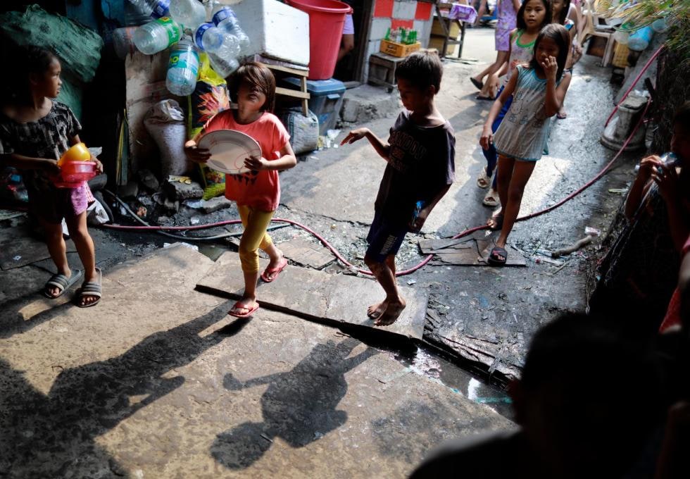 A child waits at a Project PEARLS feeding program in Manila