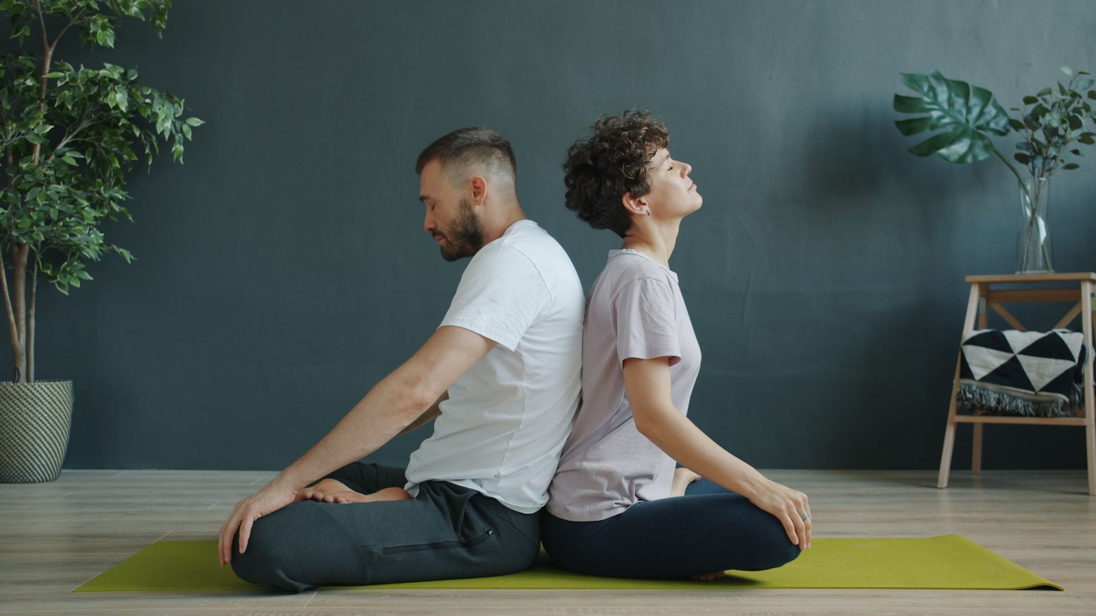 Couple practicing a back-to-back breathing exercise together