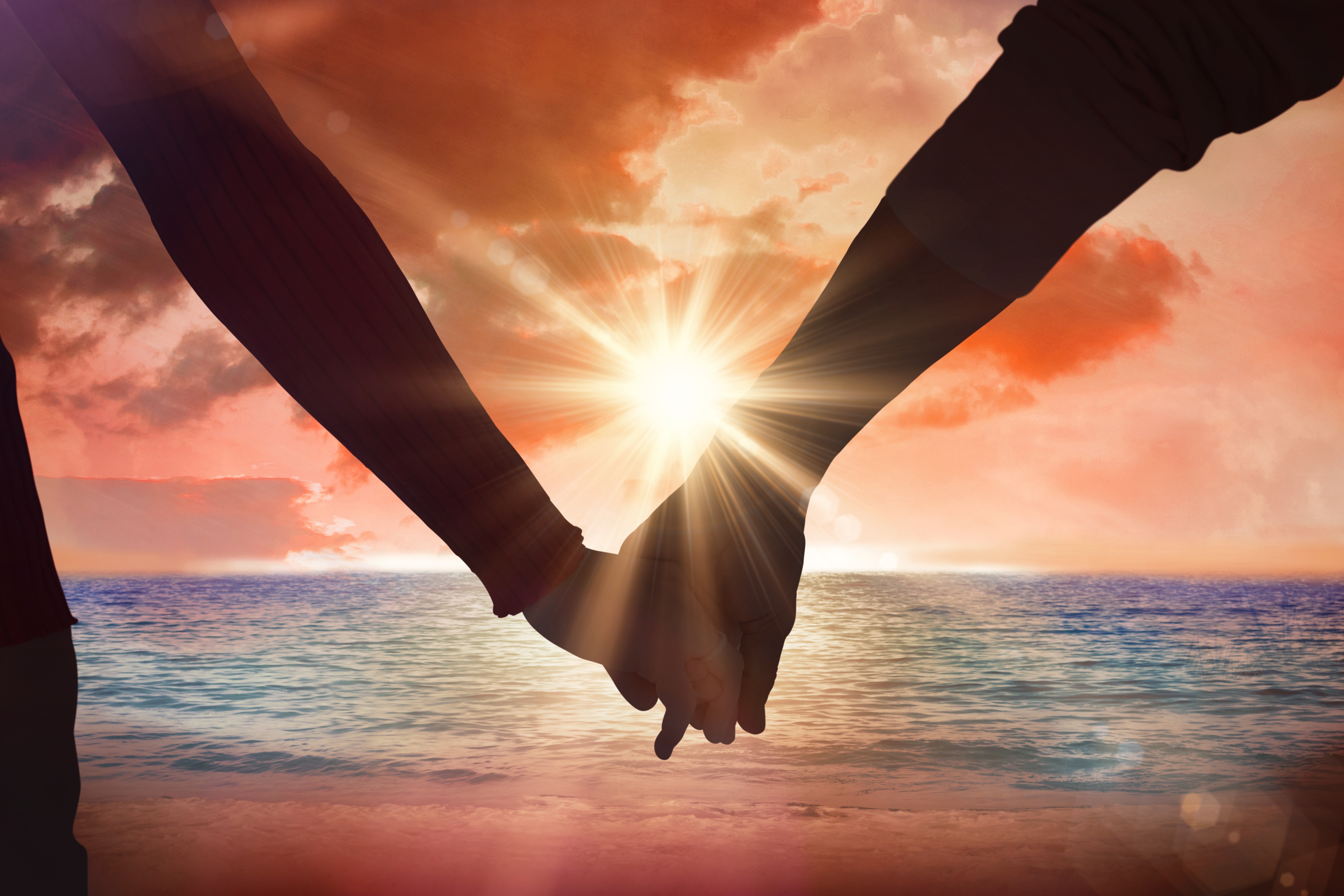 Two people holding hands while working through a difficult relationship conversation