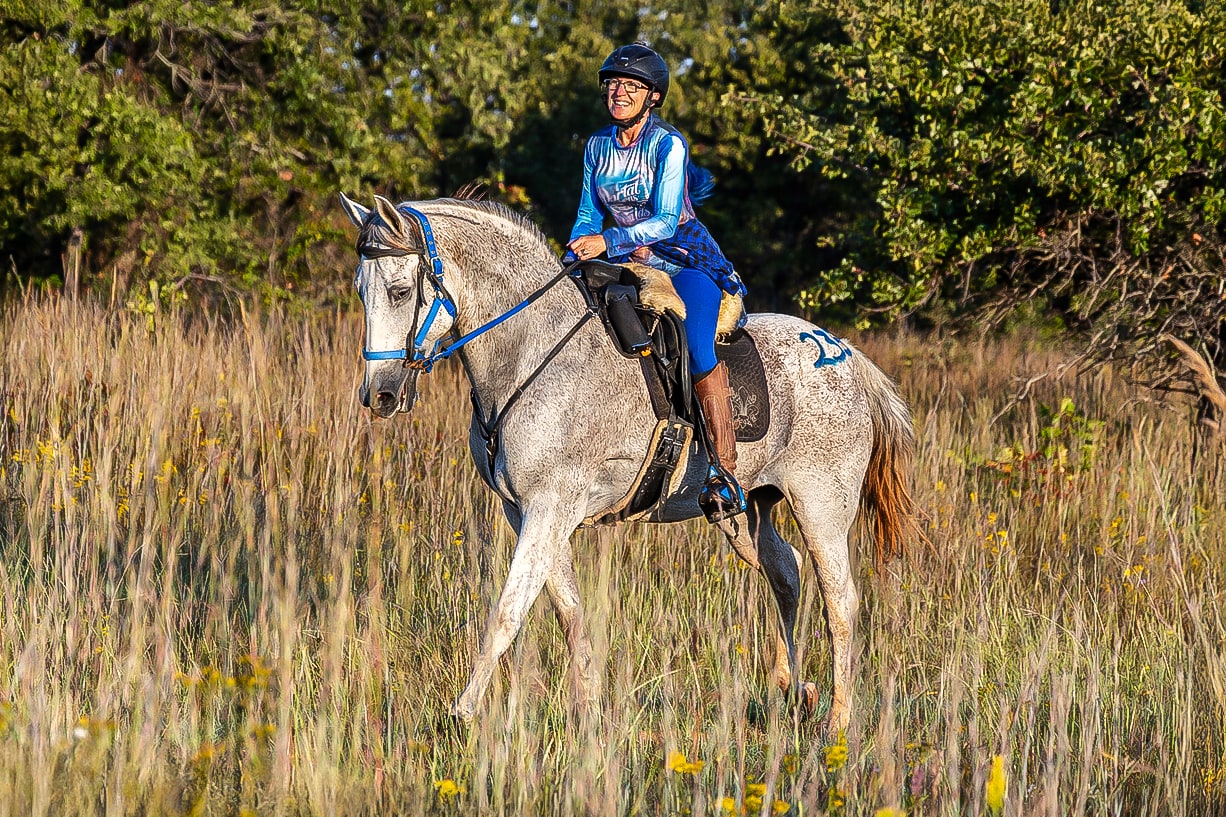 Nadine riding Oso through a Texas field