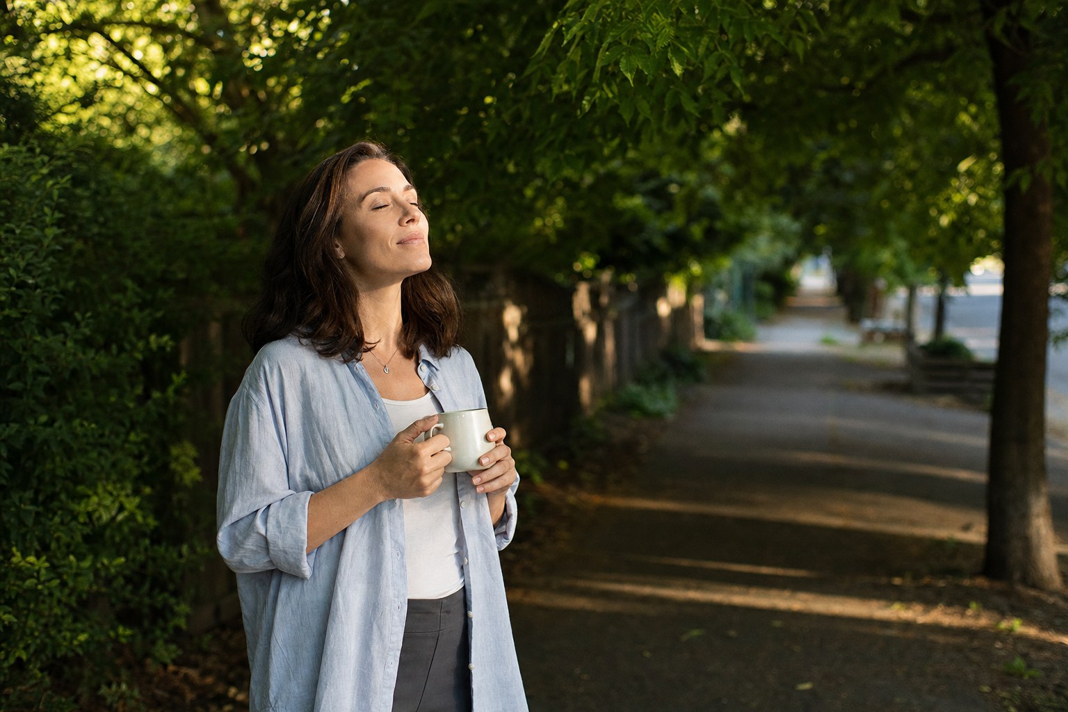 Person taking a quiet pause along a tree-lined path