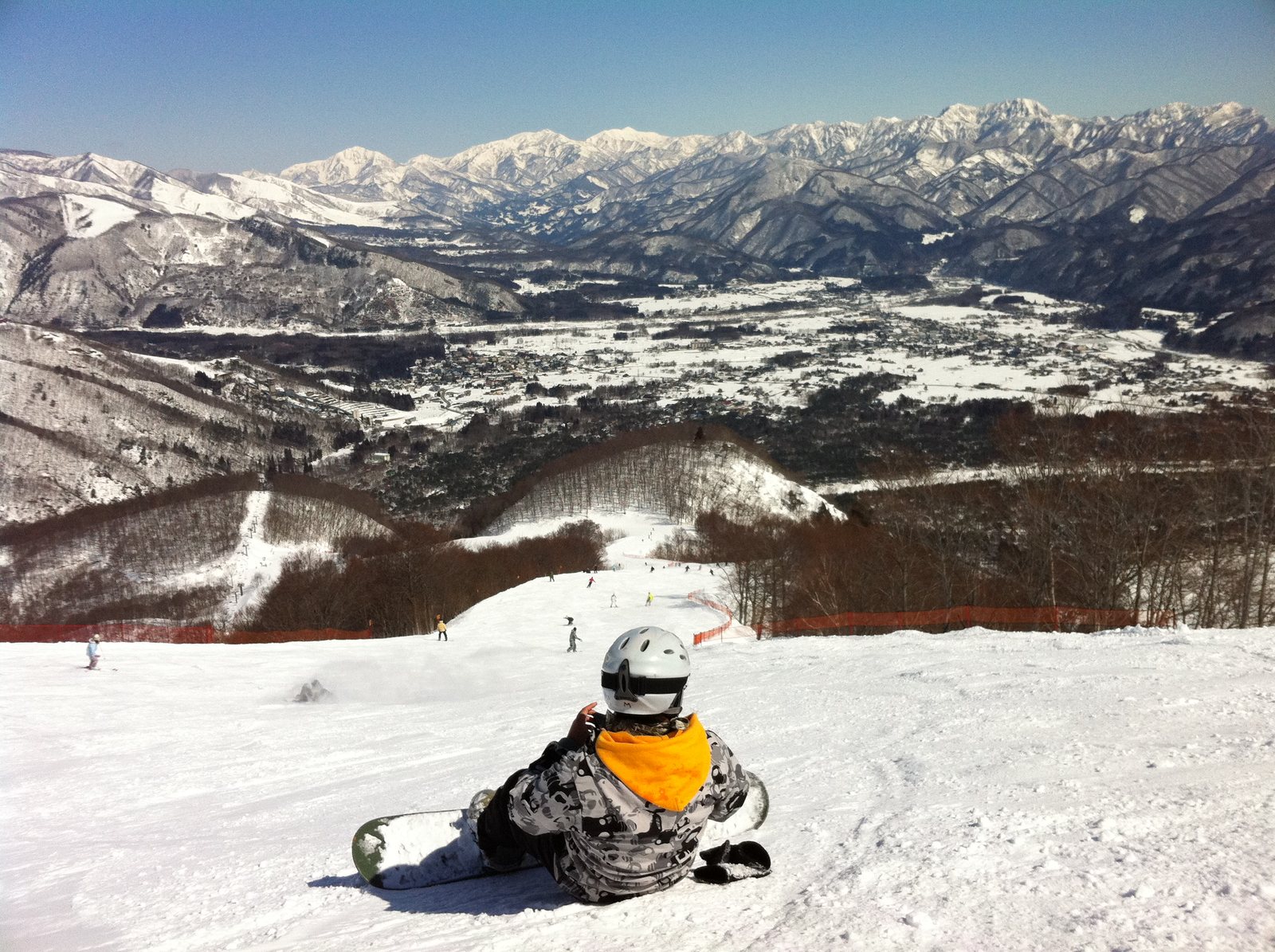 Skiers on a broad snow-covered run at Hakuba 47 with Japanese Alps scenery