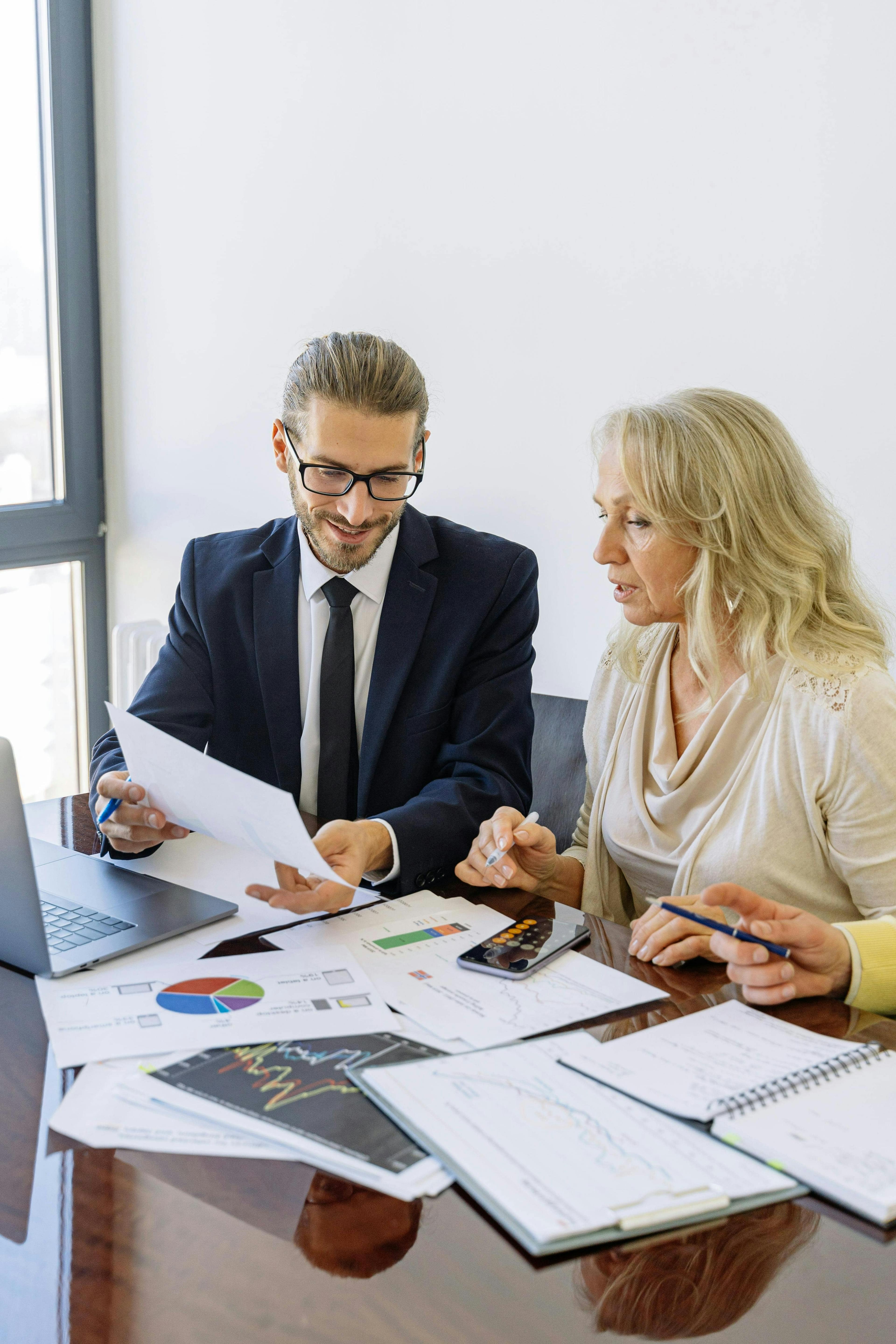 Business owner and adviser reviewing financial reports together