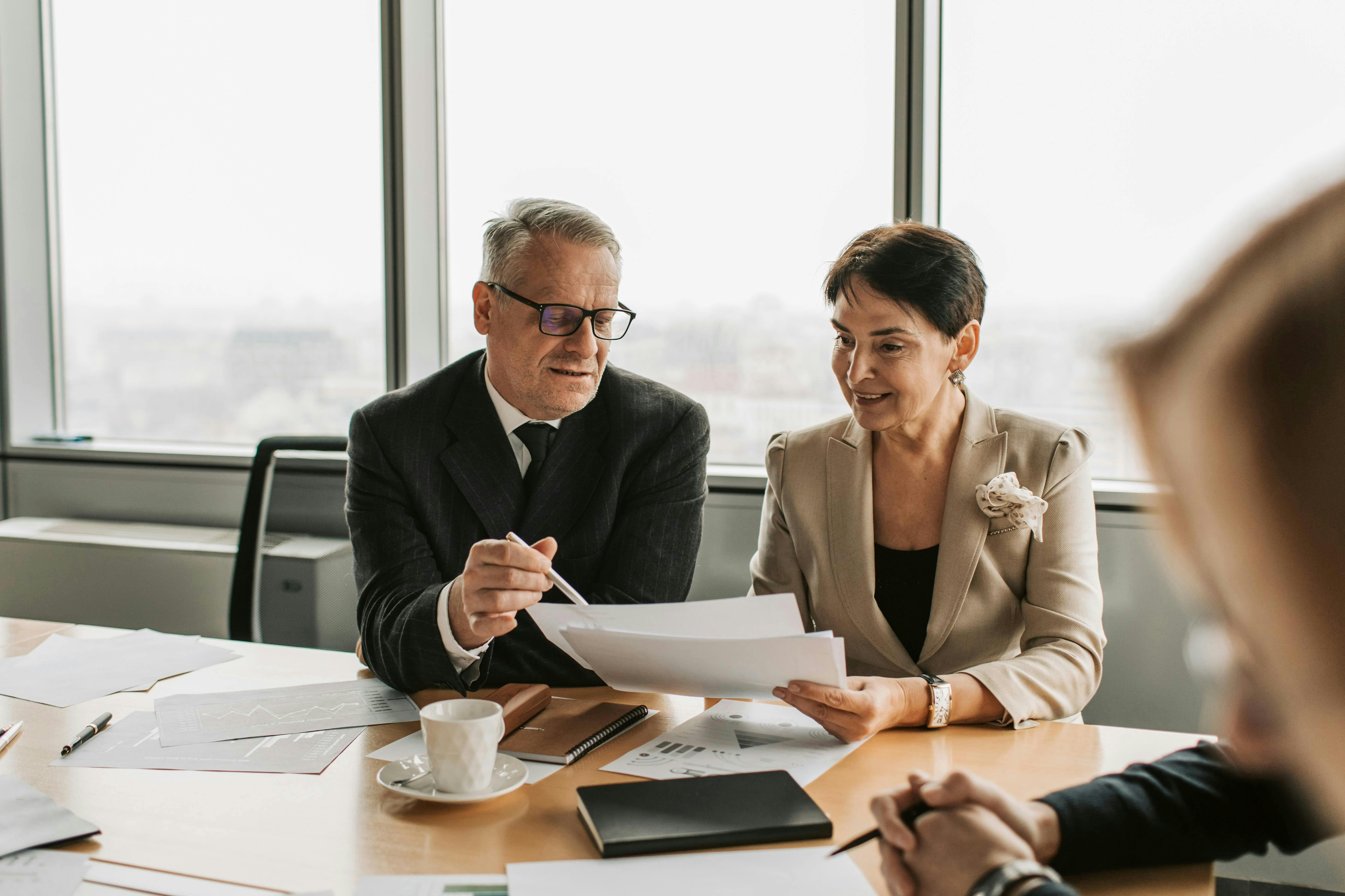 Advisers reviewing financial documents at a meeting table