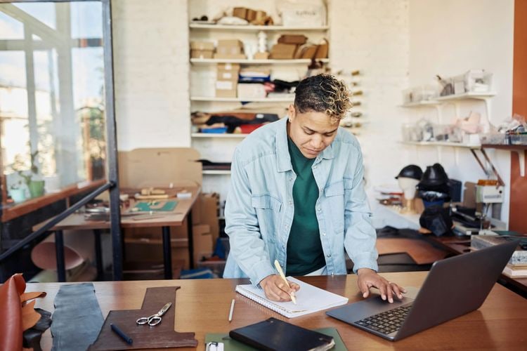 Small business owner reviewing records at a worktable