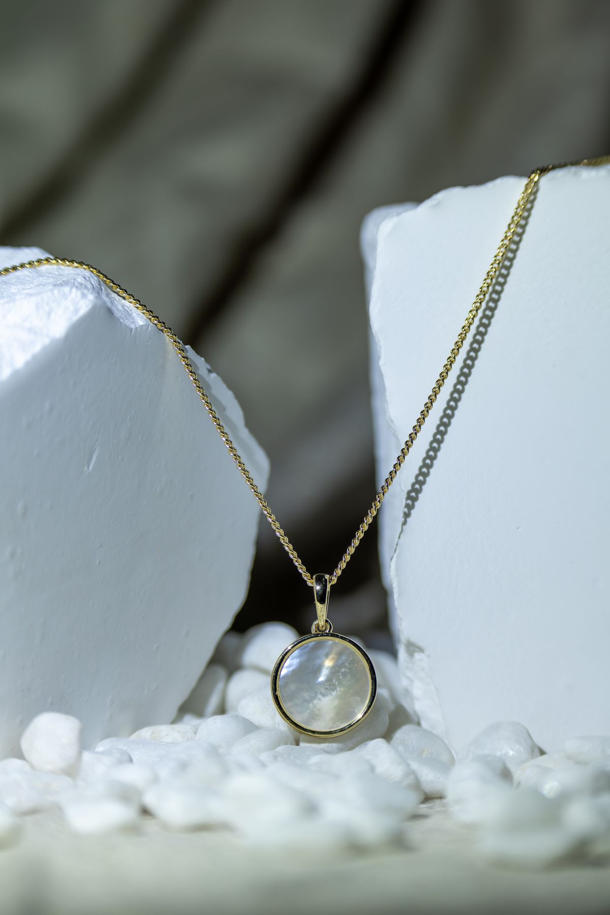 Moonstone pendant necklace on a pale stone surface