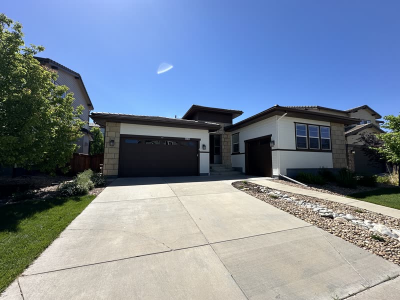 Finished white home exterior with dark trim and driveway