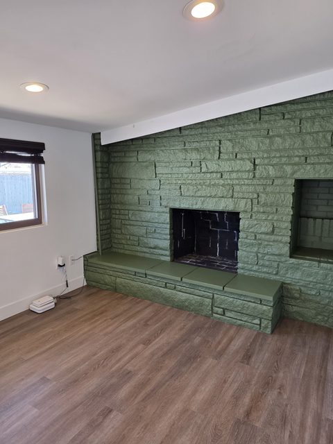 Finished interior with a green painted accent wall and wood flooring