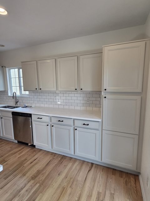 Detailed view of white kitchen cabinets and tile backsplash