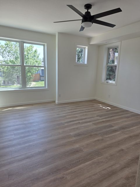 Freshly finished bright room with high ceilings and a black ceiling fan