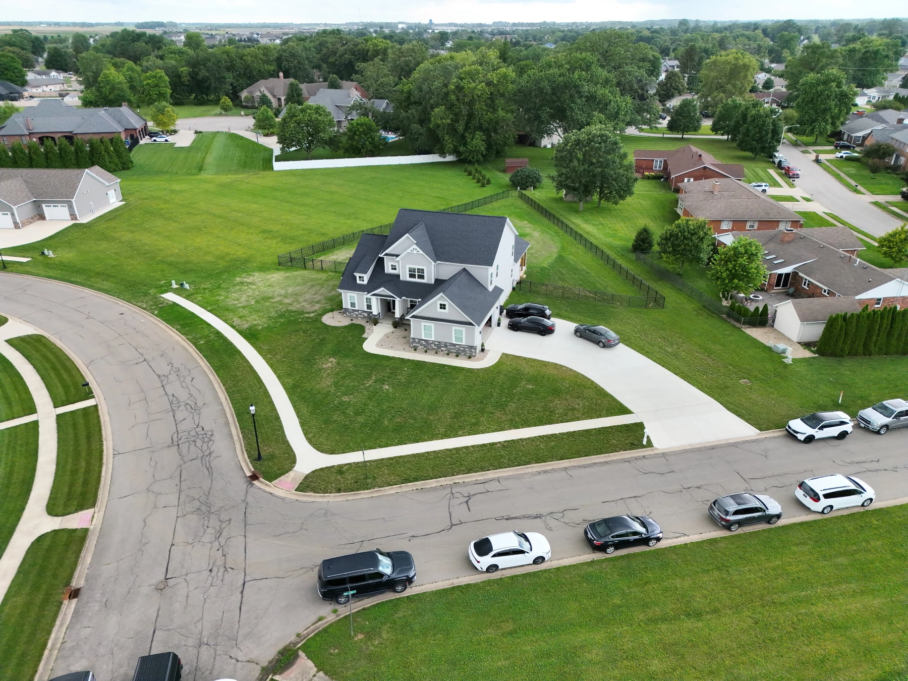 Aerial view of a home, its yard, and the surrounding neighborhood