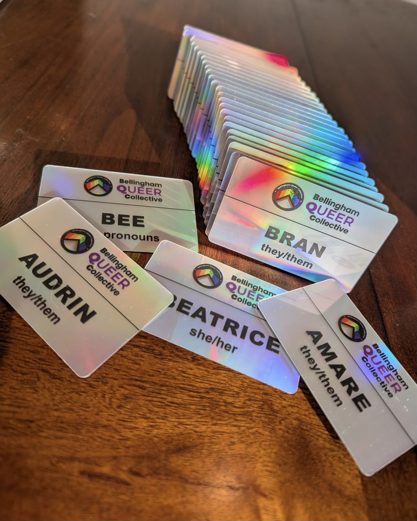 Bellingham Queer Collective badges, color printed on holographic plastic with magnetic backs