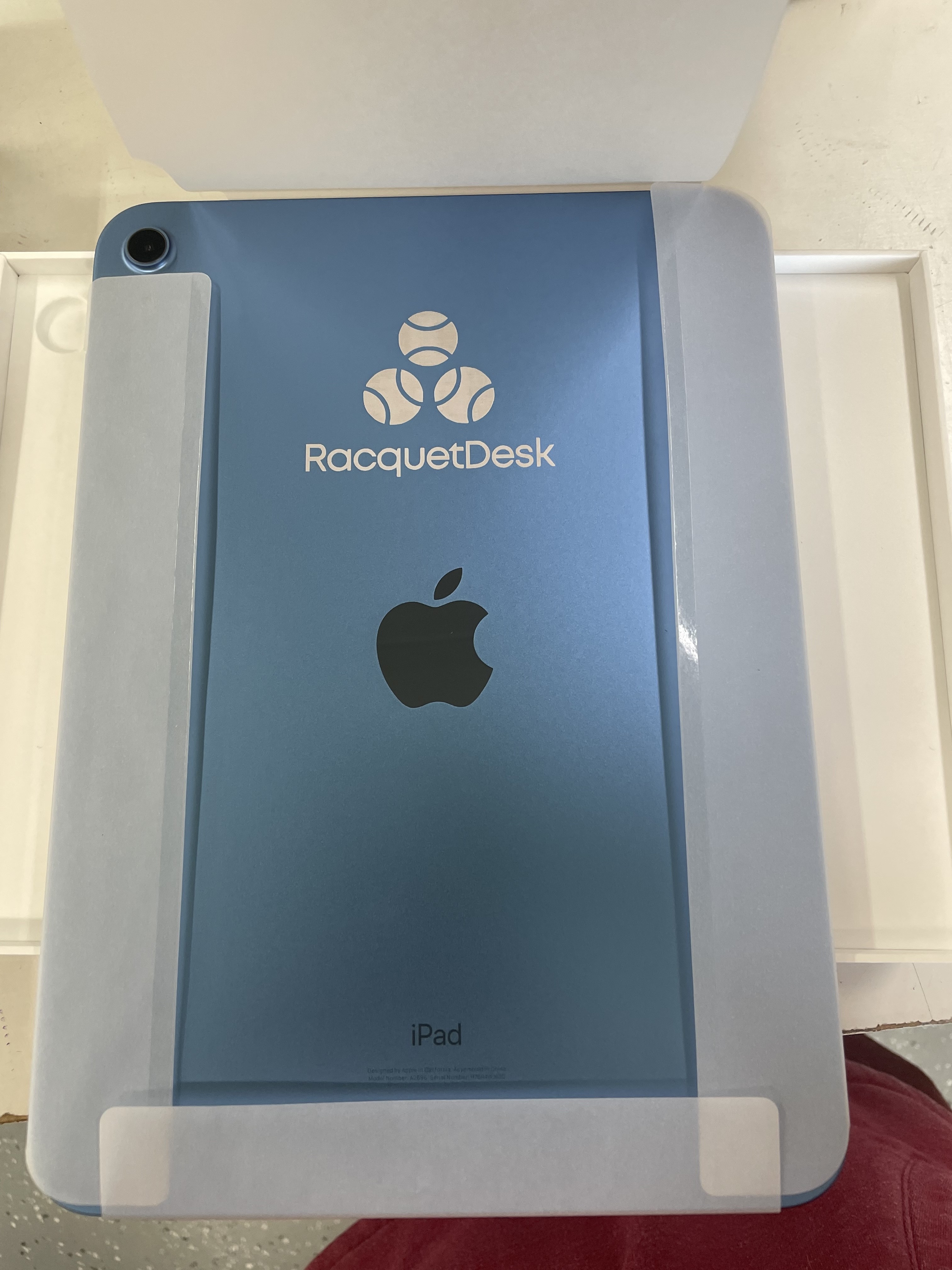 A custom-branded blue iPad in its original box