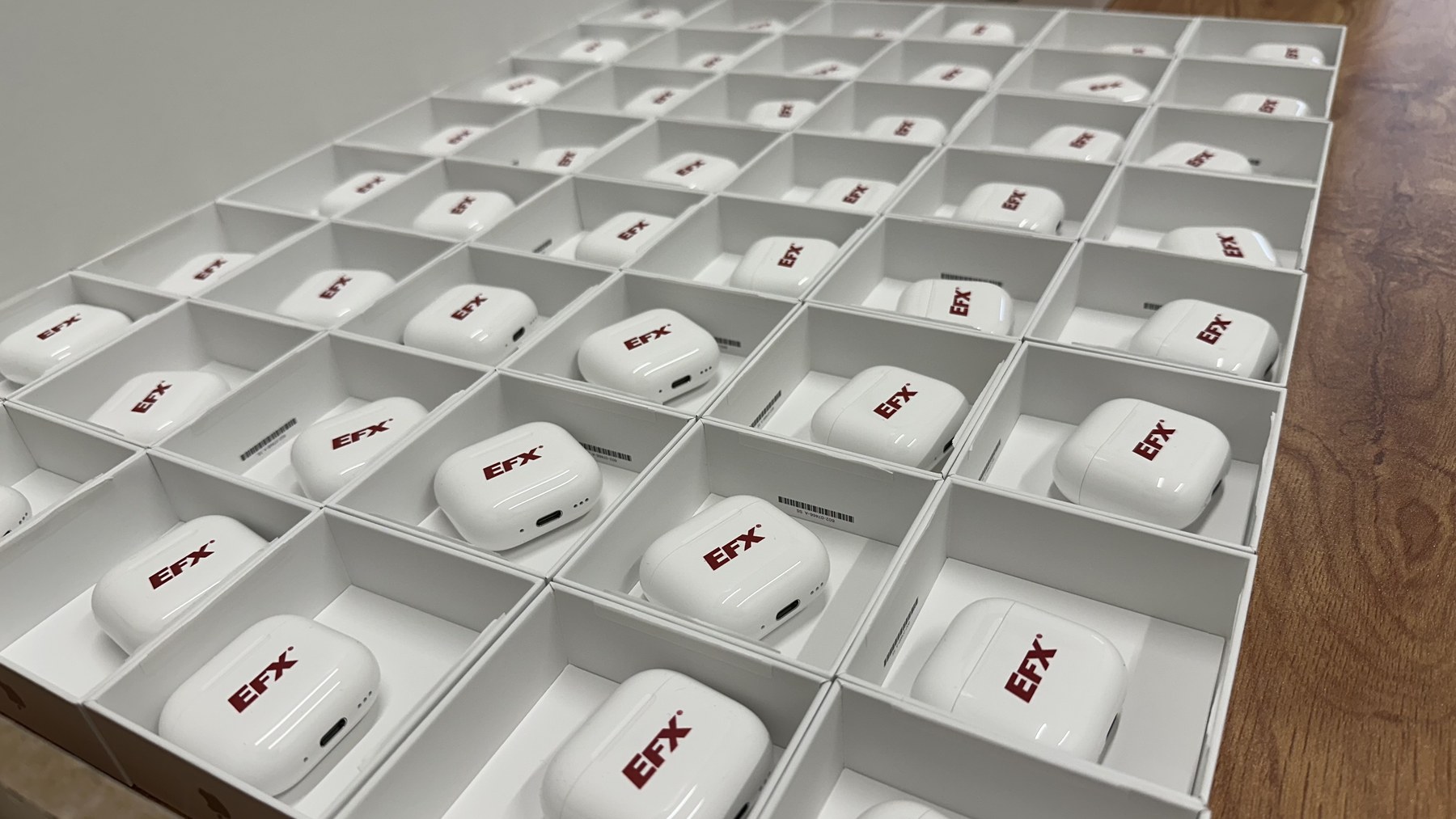 A grid of custom-branded AirPods cases prepared for production
