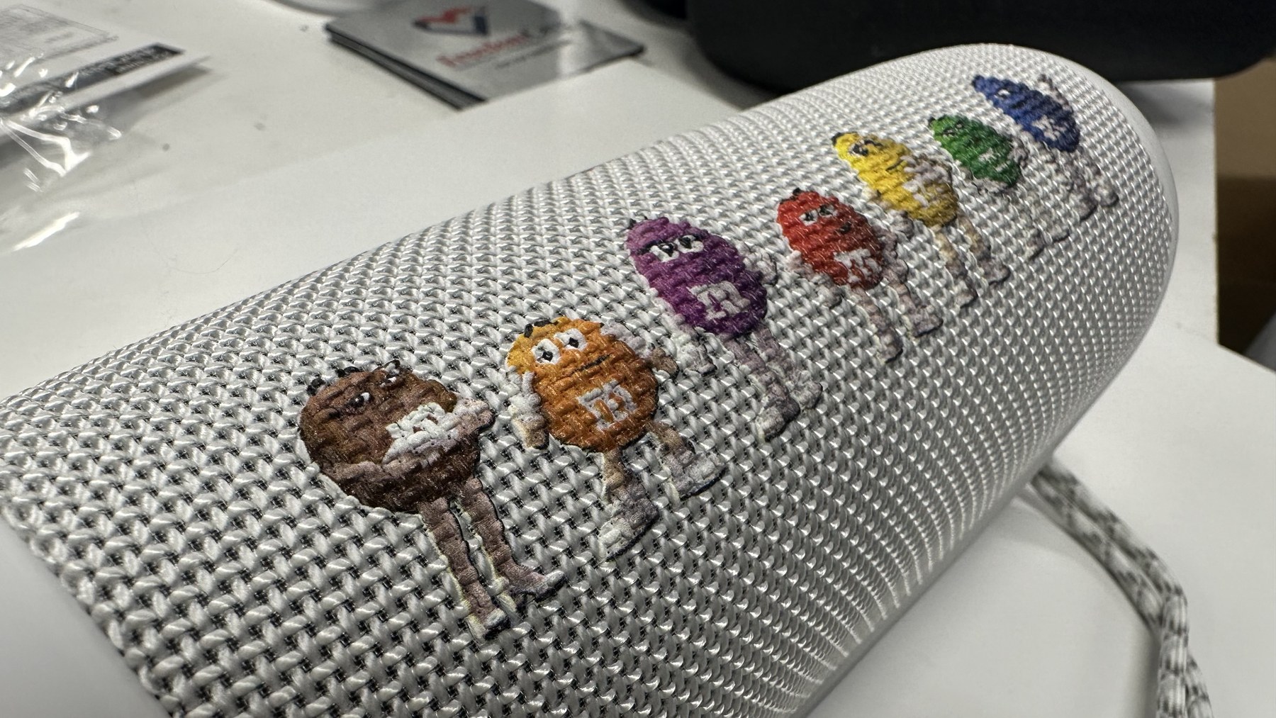 A custom M&M graphic printed on a fabric-covered speaker