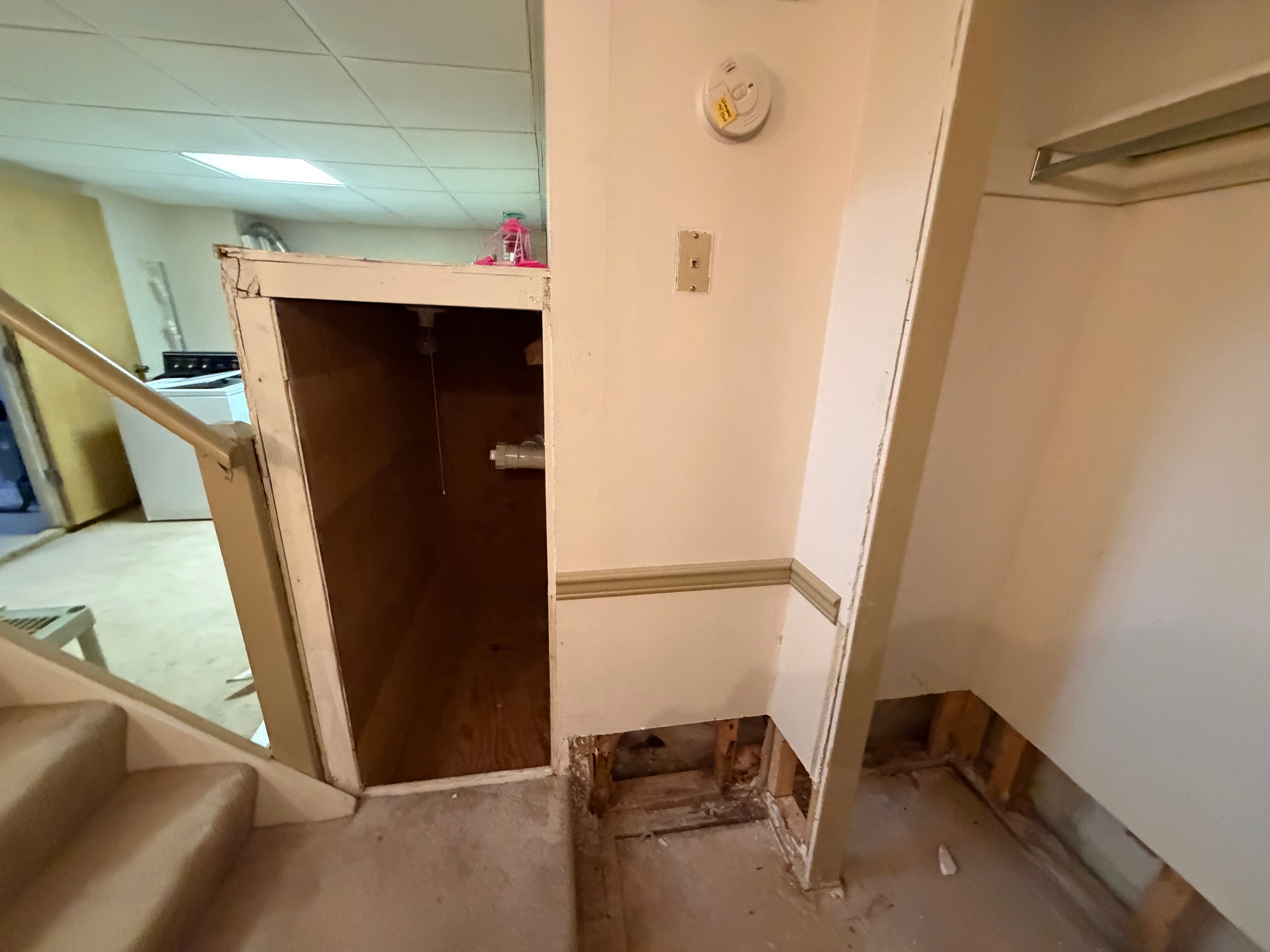 Basement utility enclosure beside the stairs before renovation