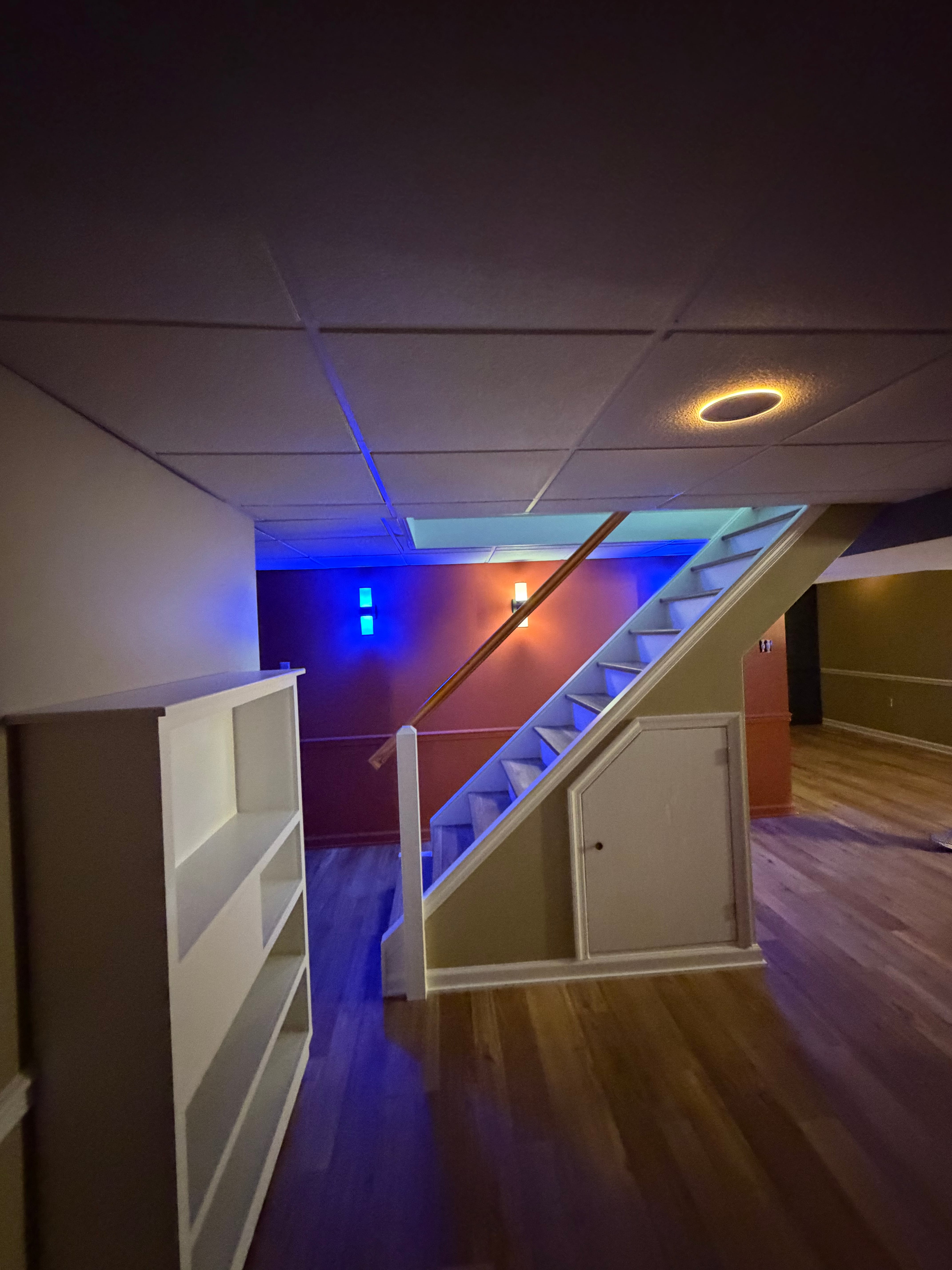 Renovated basement stairs with new handrail and blue accent lighting