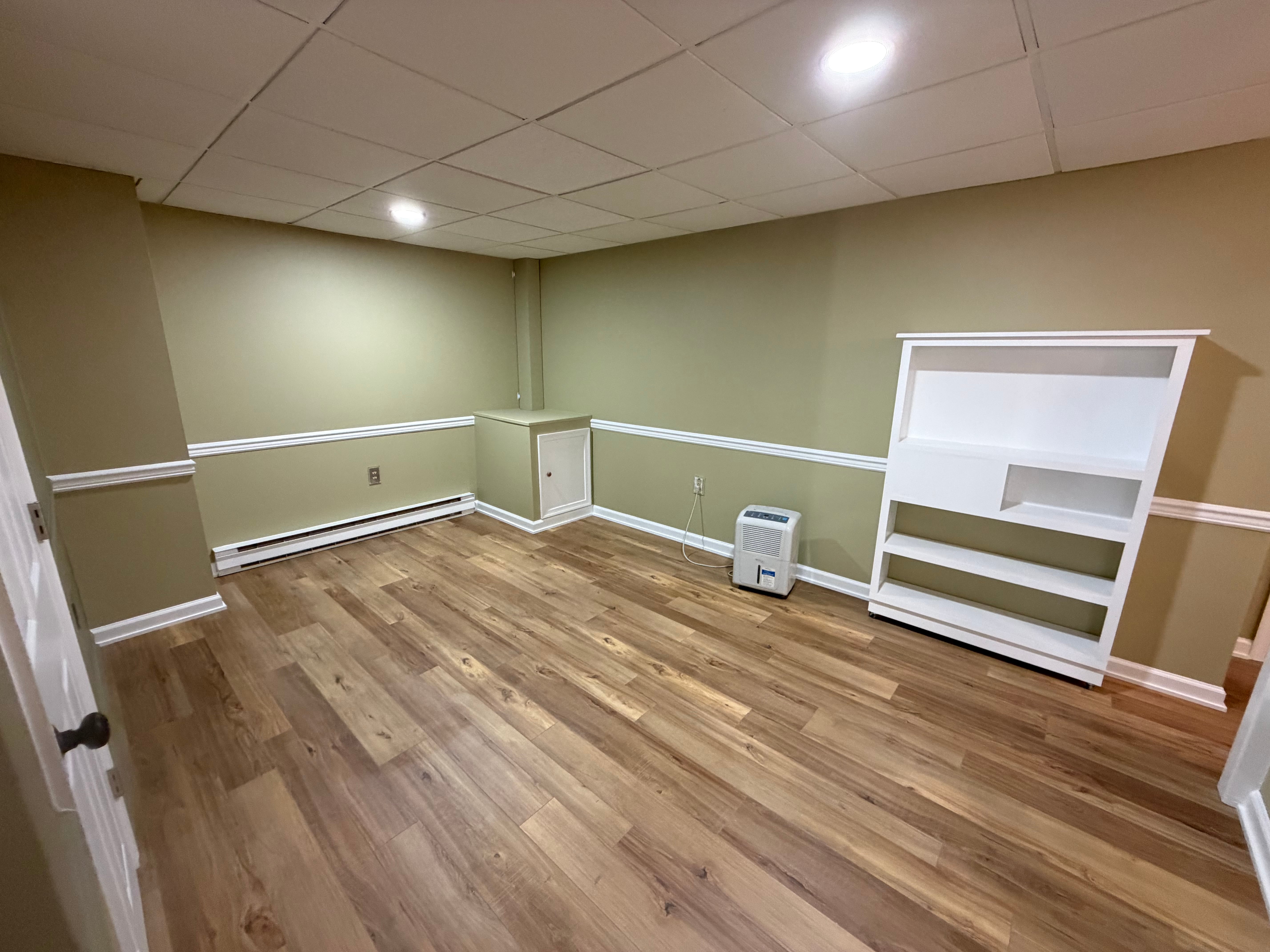Finished Remidy Renovations basement with a comfortable seating area and warm finishes