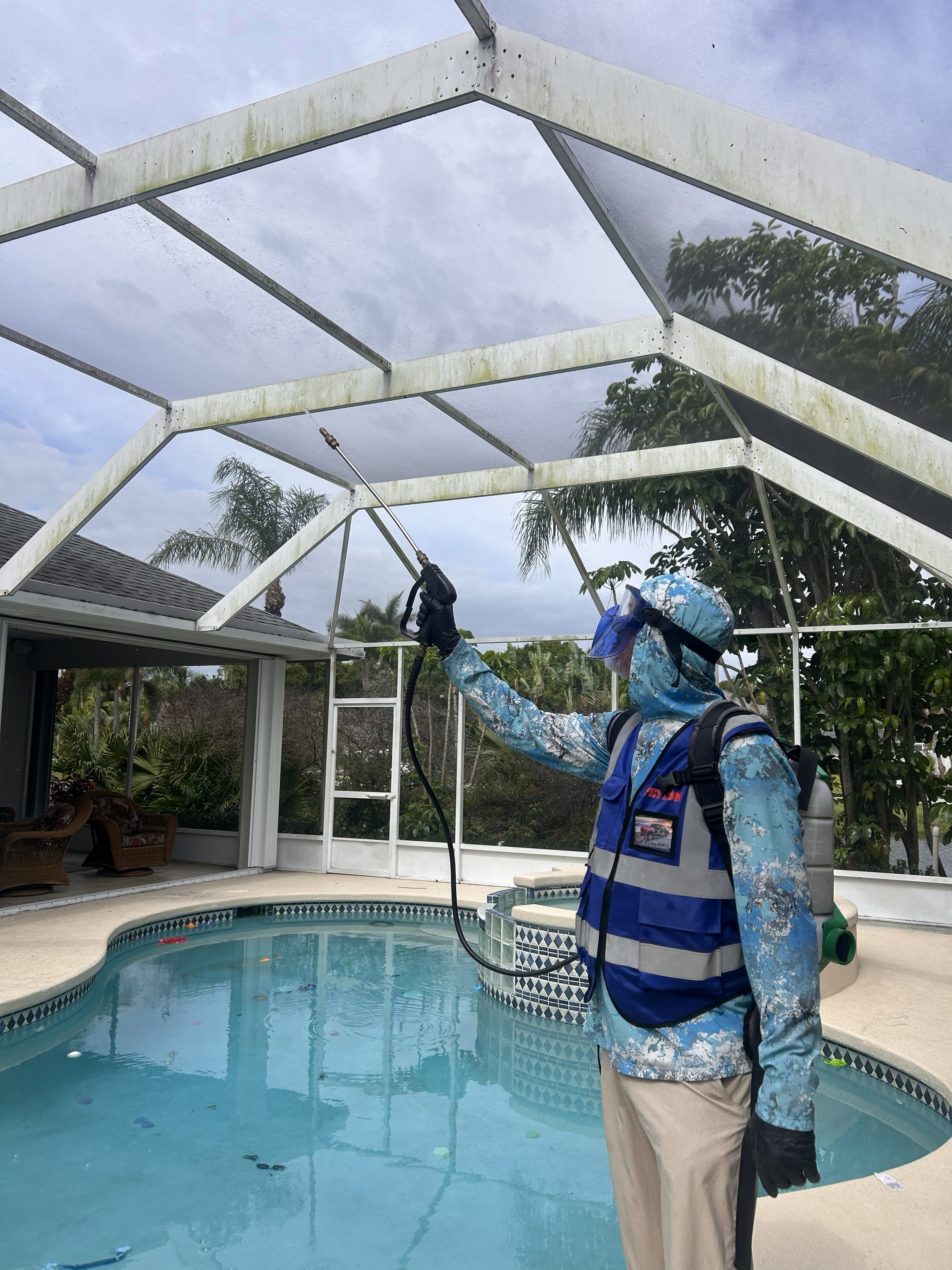 Peyton’s Pest Prevention technician treating a screened pool enclosure