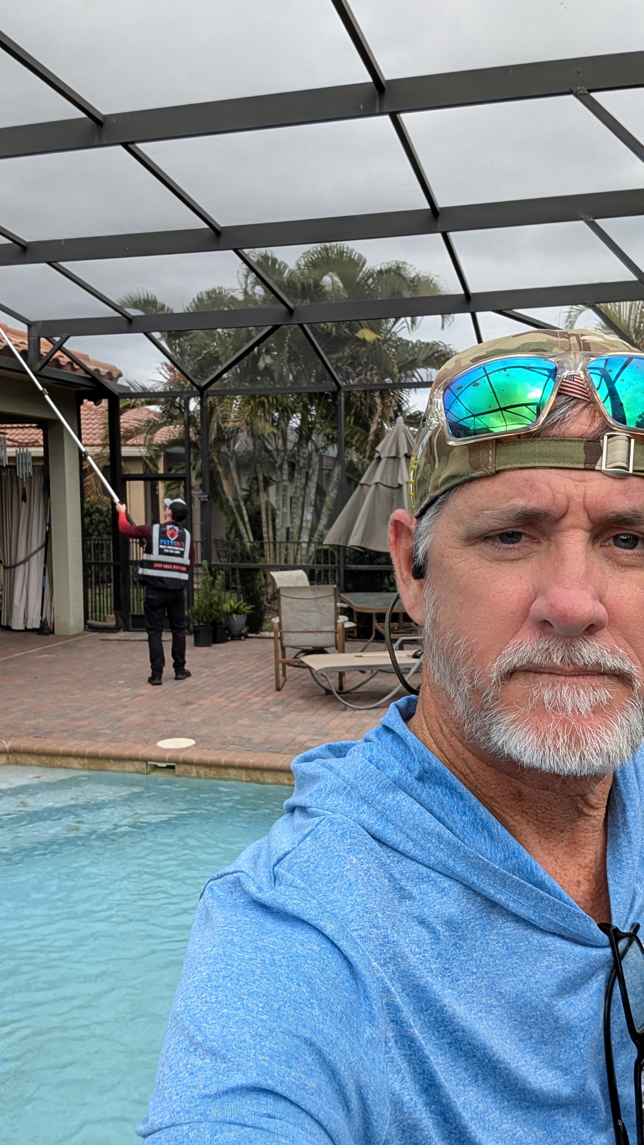 Peyton’s Pest Prevention team providing service around a screened Florida patio