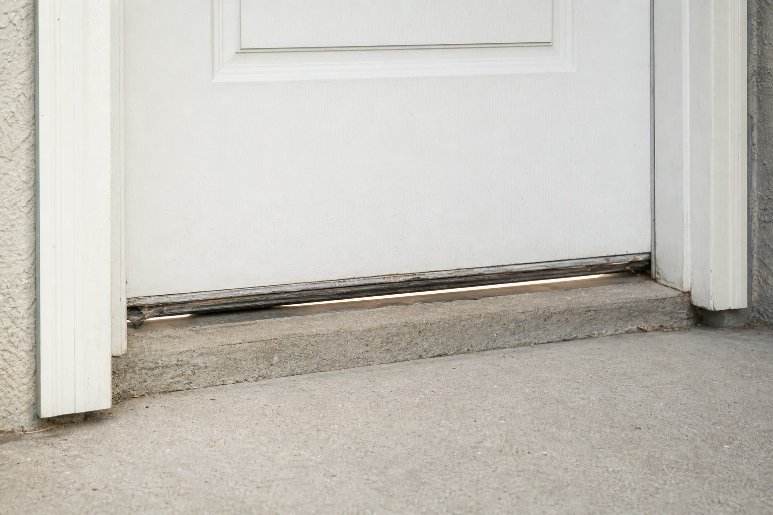 Gap beneath a worn exterior door sweep