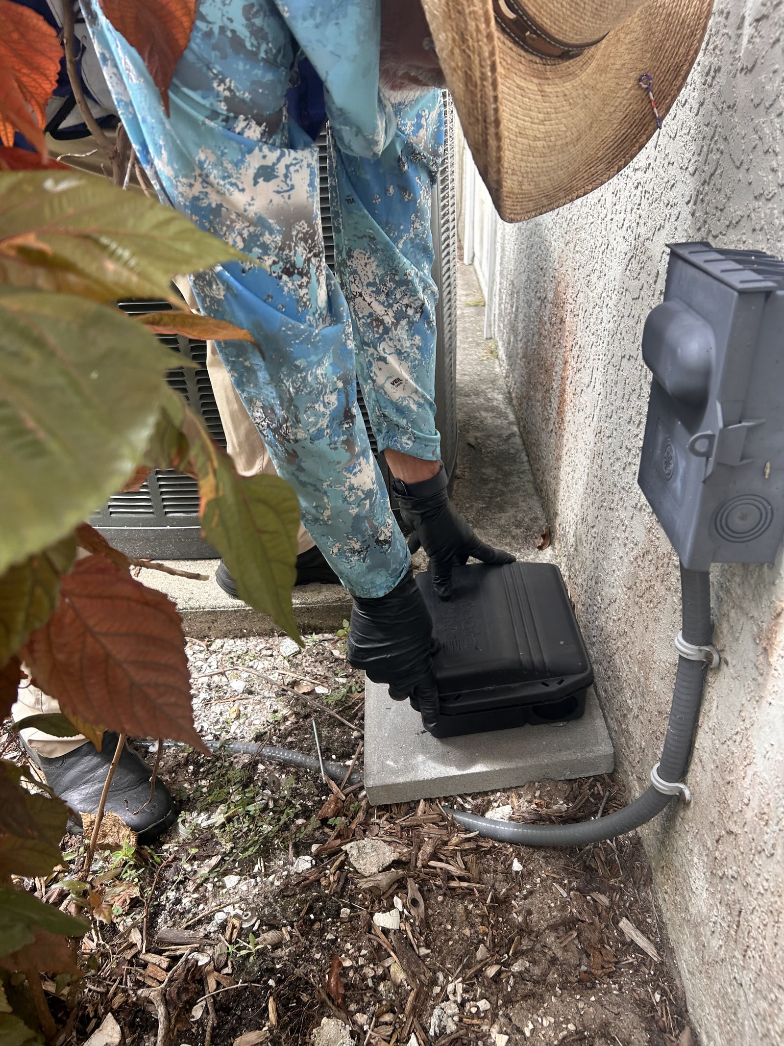 Peyton’s Pest Prevention technician servicing an exterior pest station