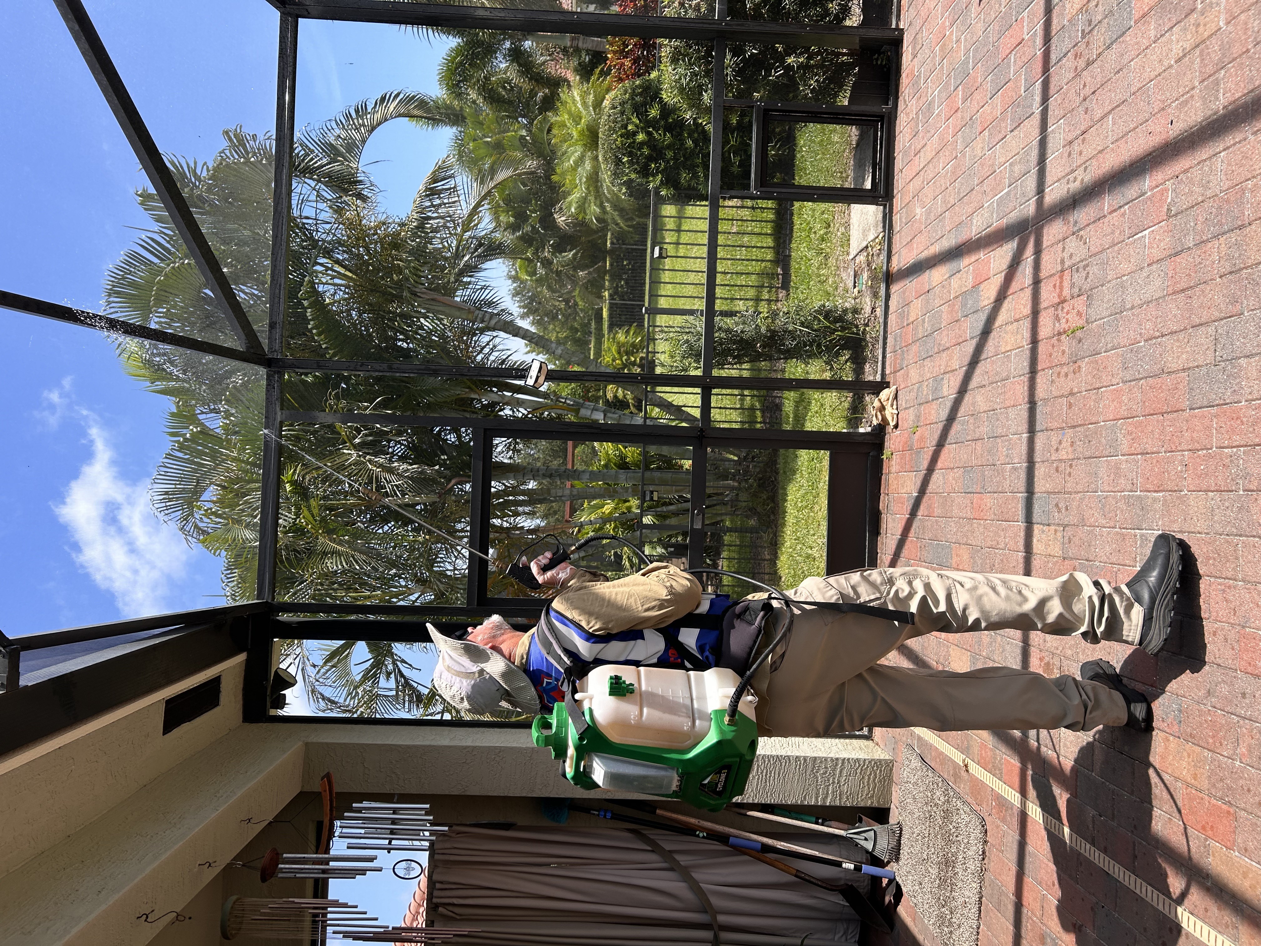 Peyton’s Pest Prevention technician treating a screened pool enclosure