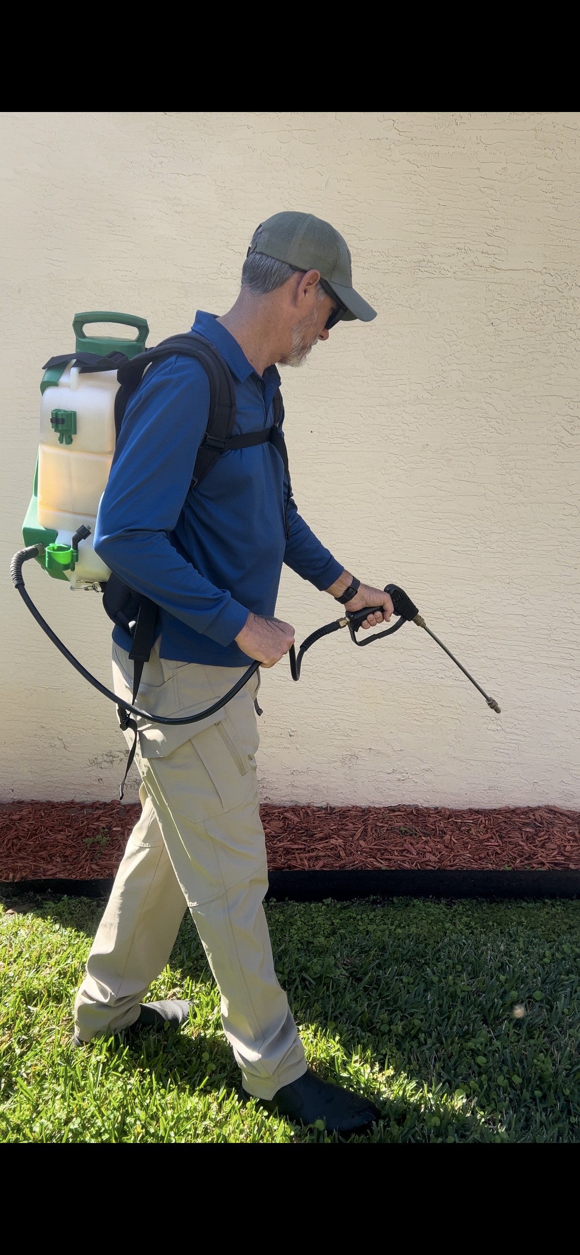 Pest control technician treating around a Florida home
