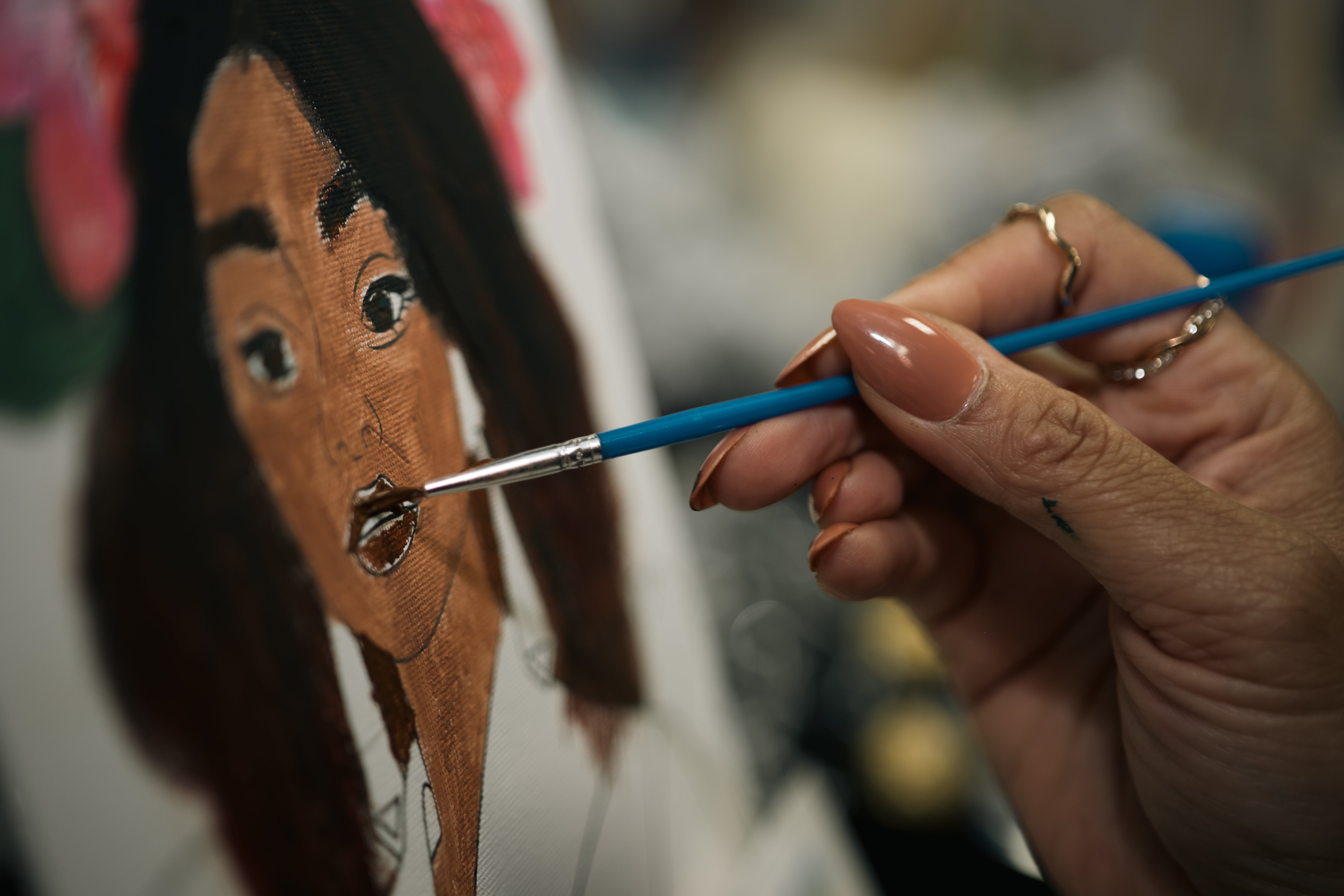 Artist painting details on a portrait canvas