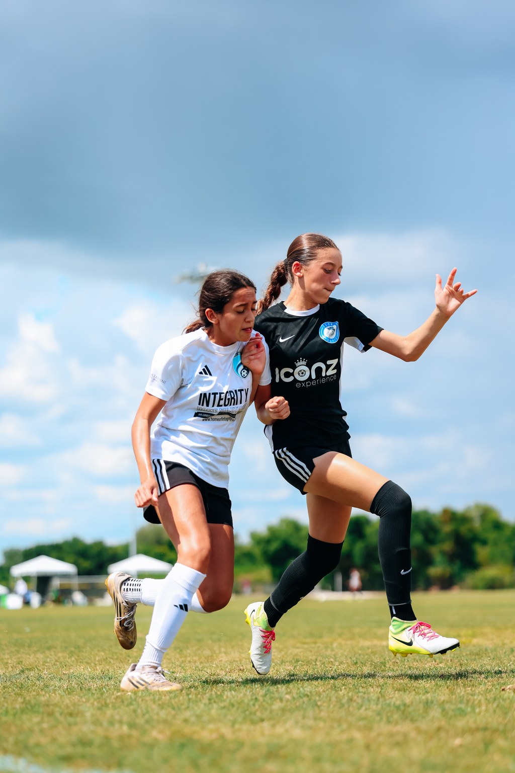 Two youth soccer players competing for position during a game