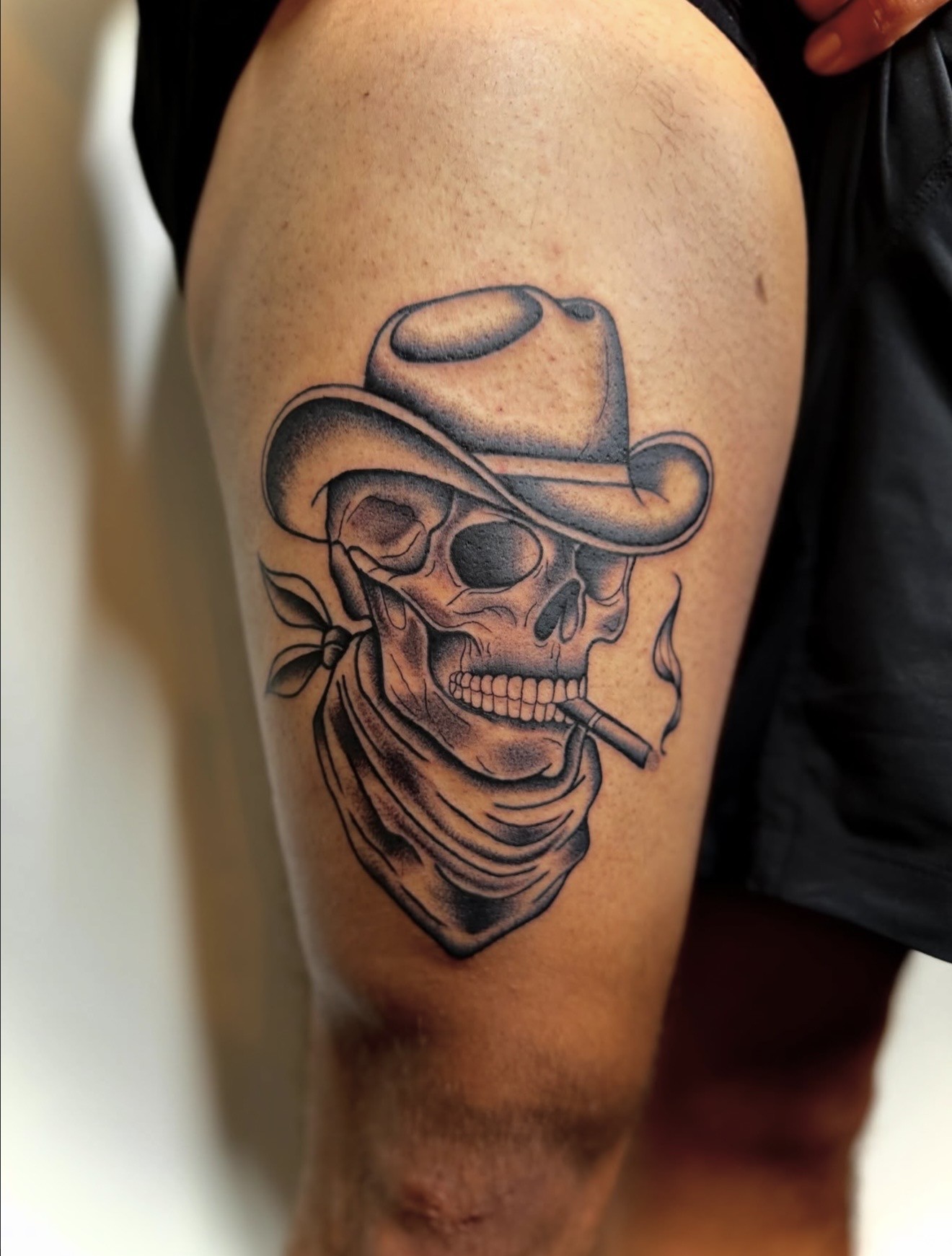 Black and gray cowboy skull tattoo on a client's arm