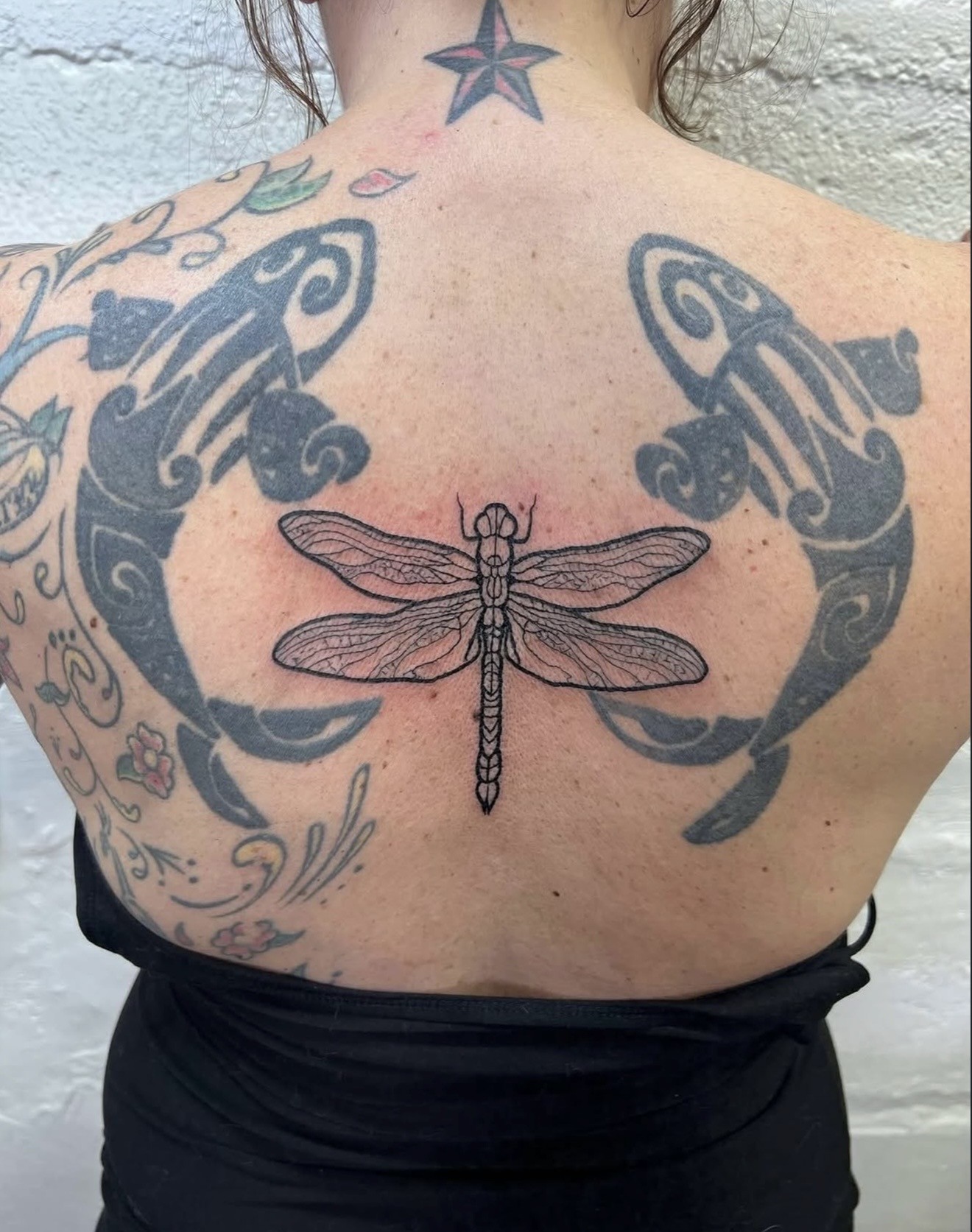 Fine line dragonfly tattoo with space around the design