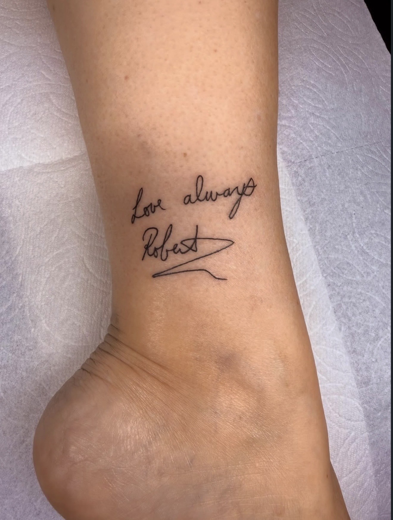 Fine line script tattoo placed along a client's arm