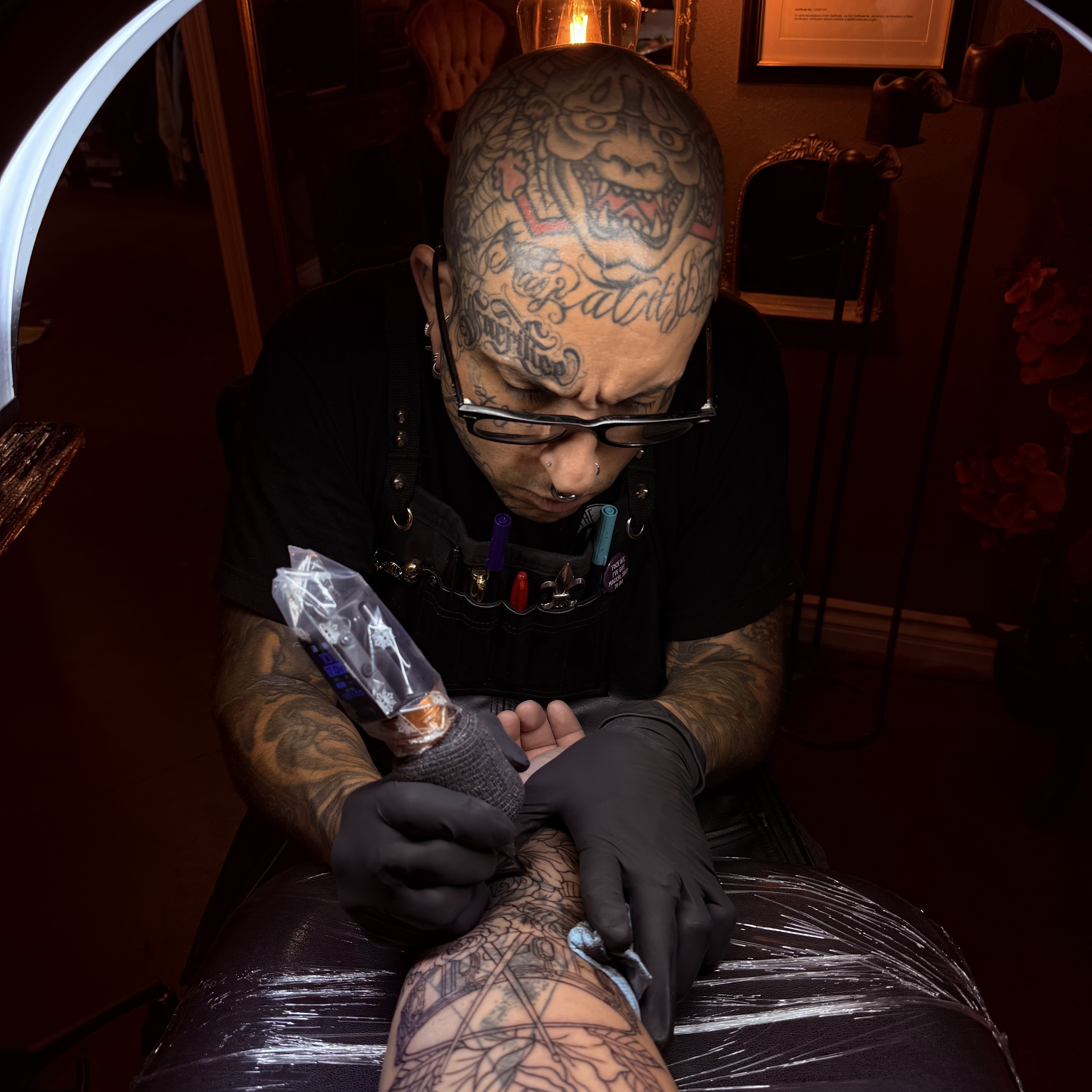 Trent Stone tattooing a client in the private studio