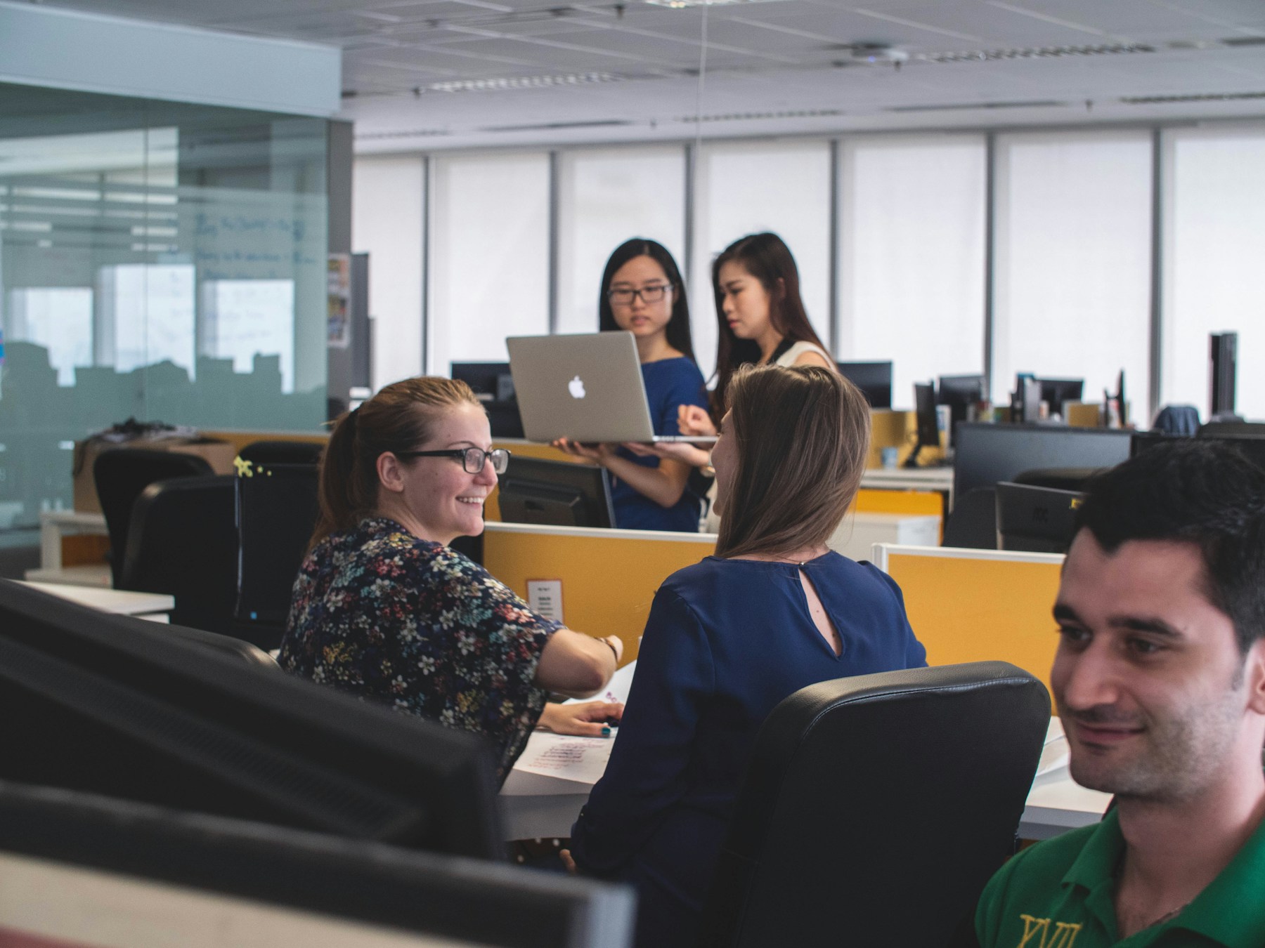 Colleagues discussing work in a bright office