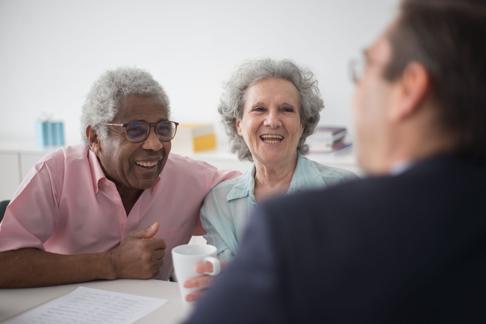 Senior couple talking with an advisor at a table