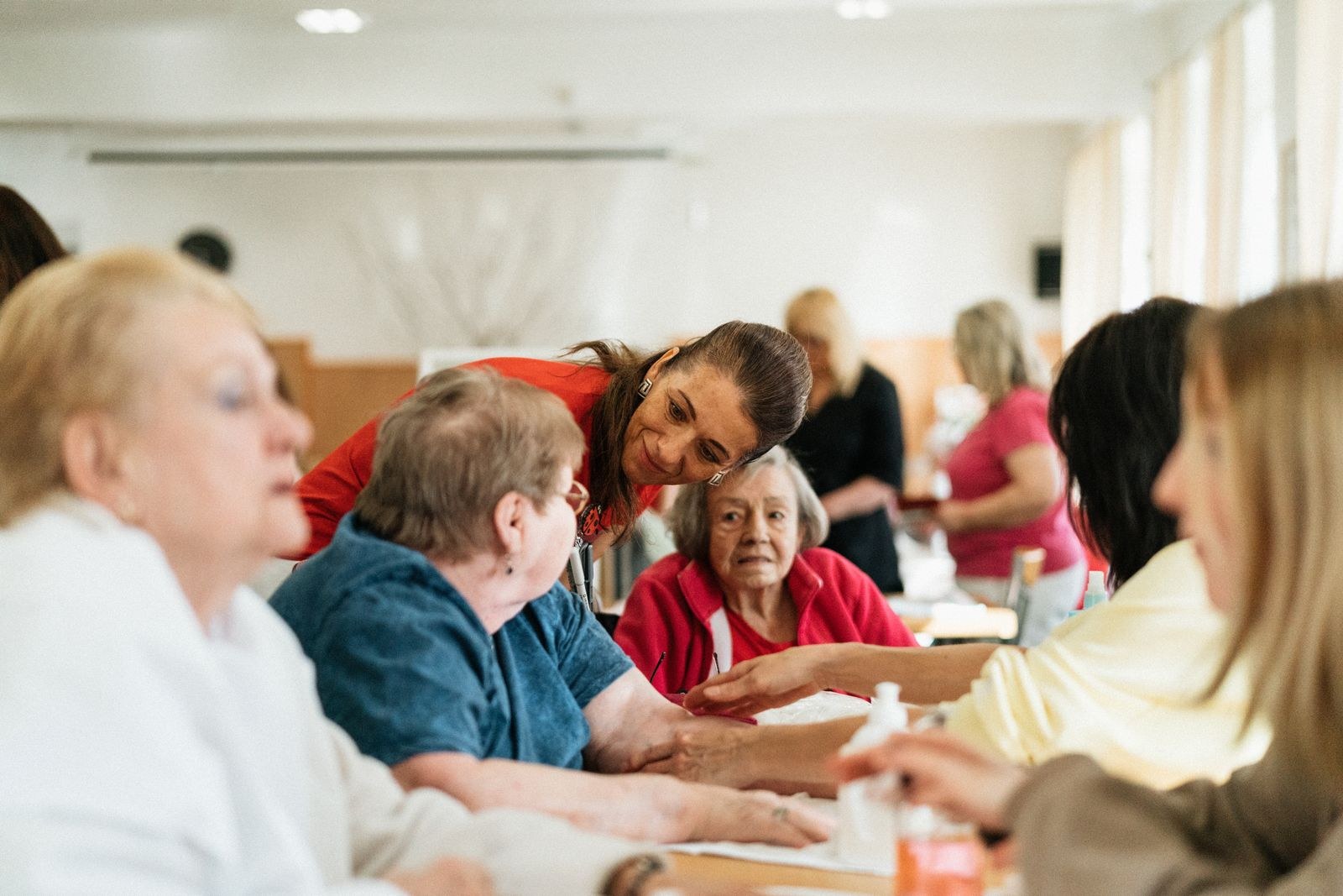 Seniors and caregivers sharing an activity around a table