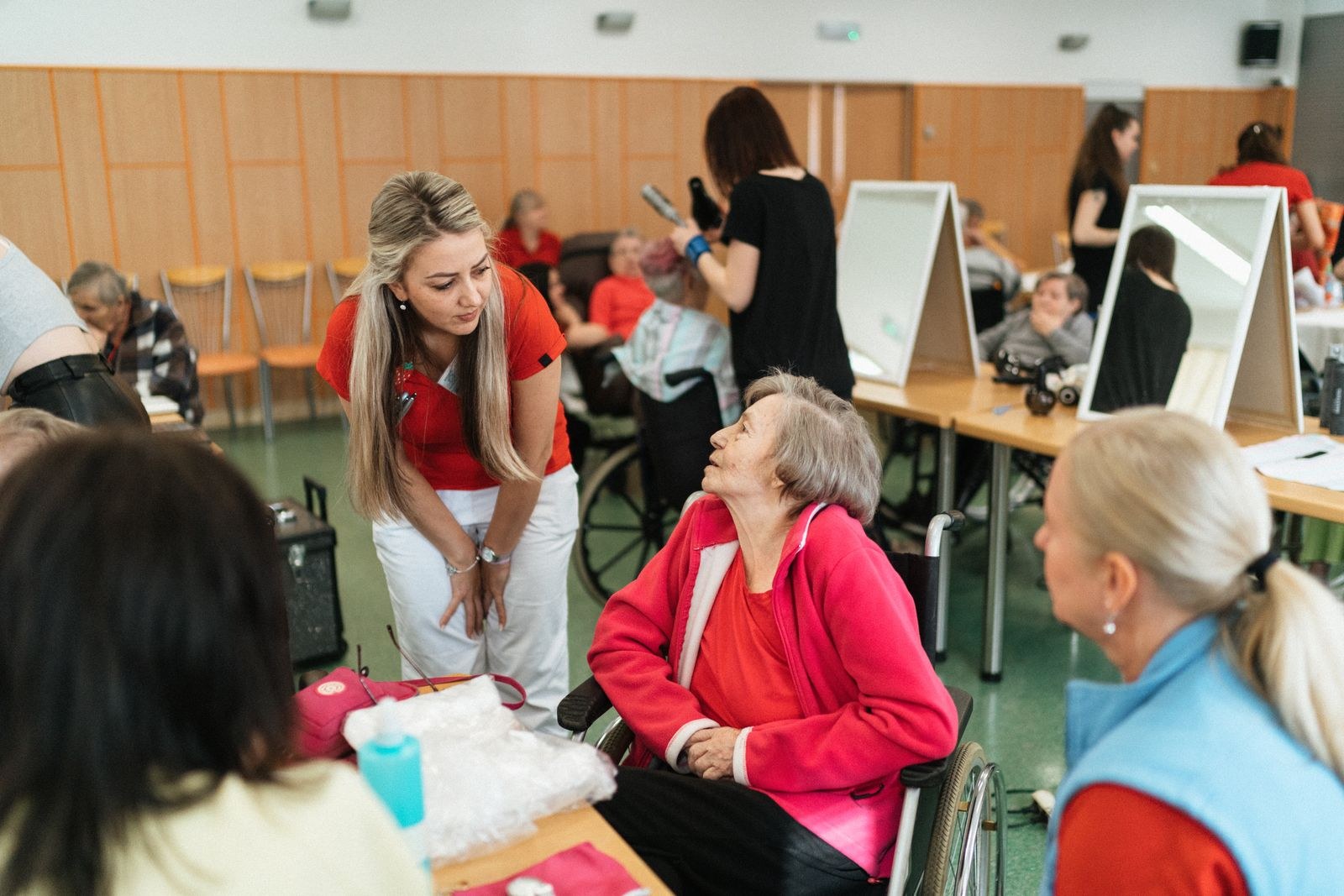 Caregiver talking with a senior woman seated in a wheelchair
