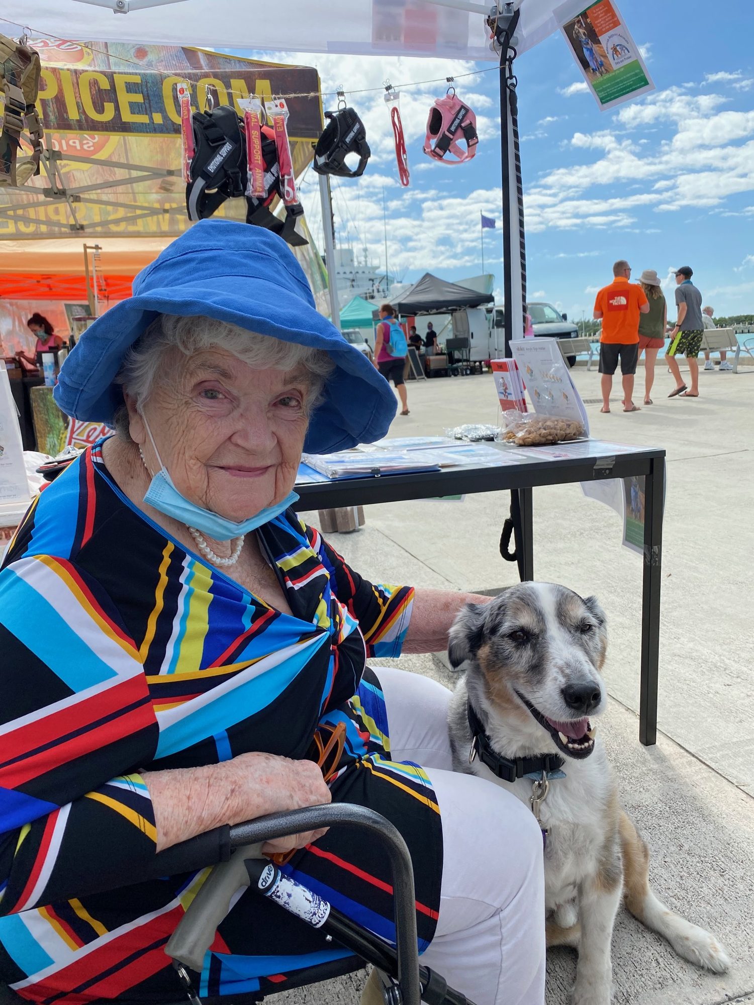 Woman seated beside a dog at an outdoor event