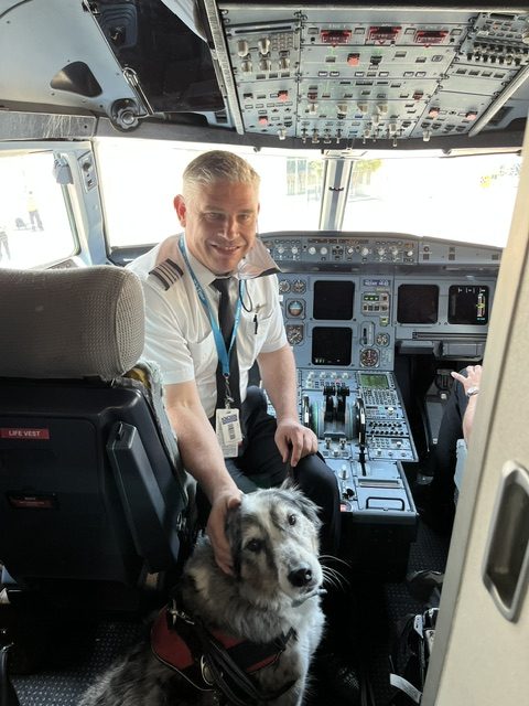 Dog beside a pilot in an aircraft cockpit