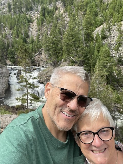Two American Support Animals team members outdoors beside a waterfall