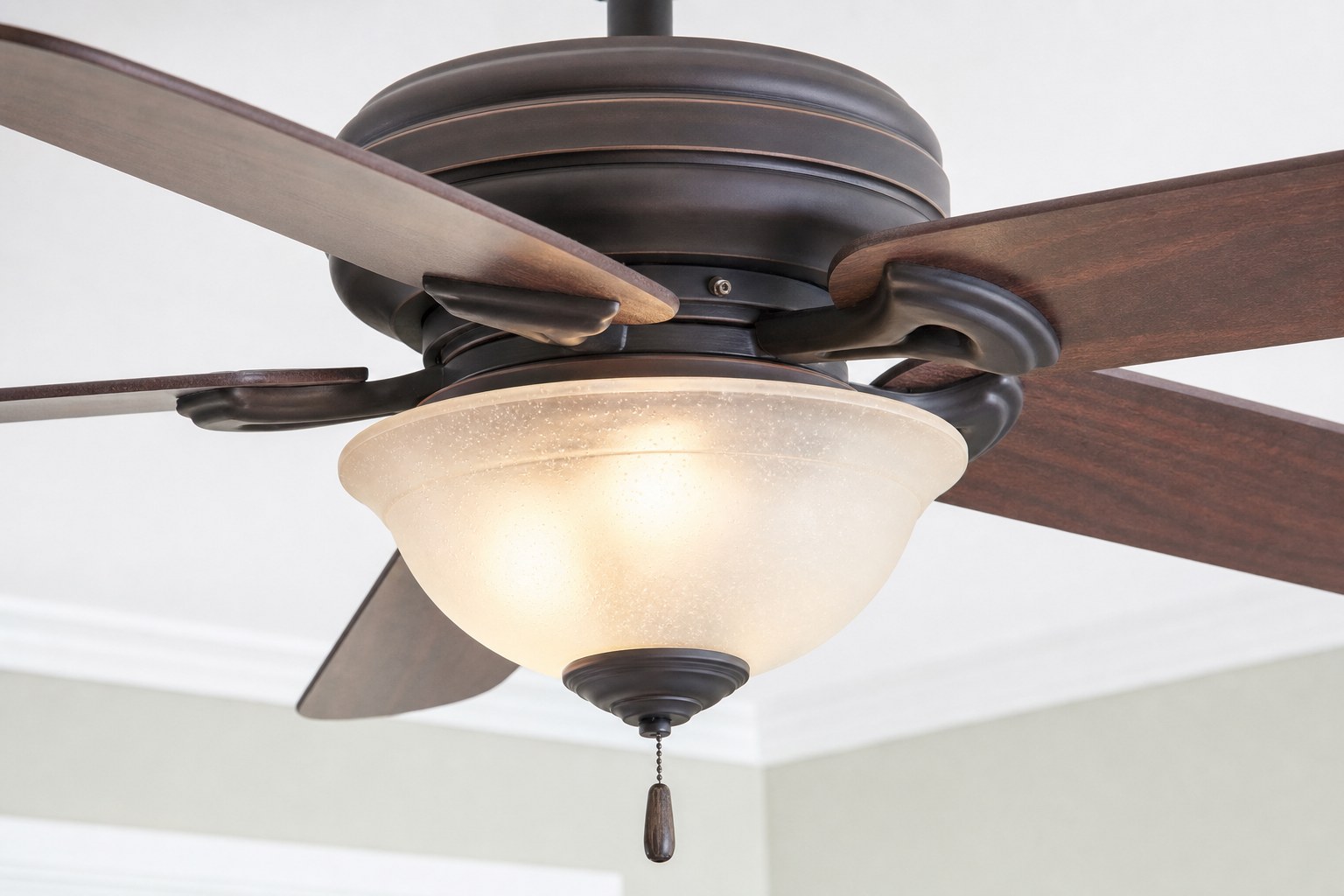 Close view of a ceiling fan light kit and glass shade