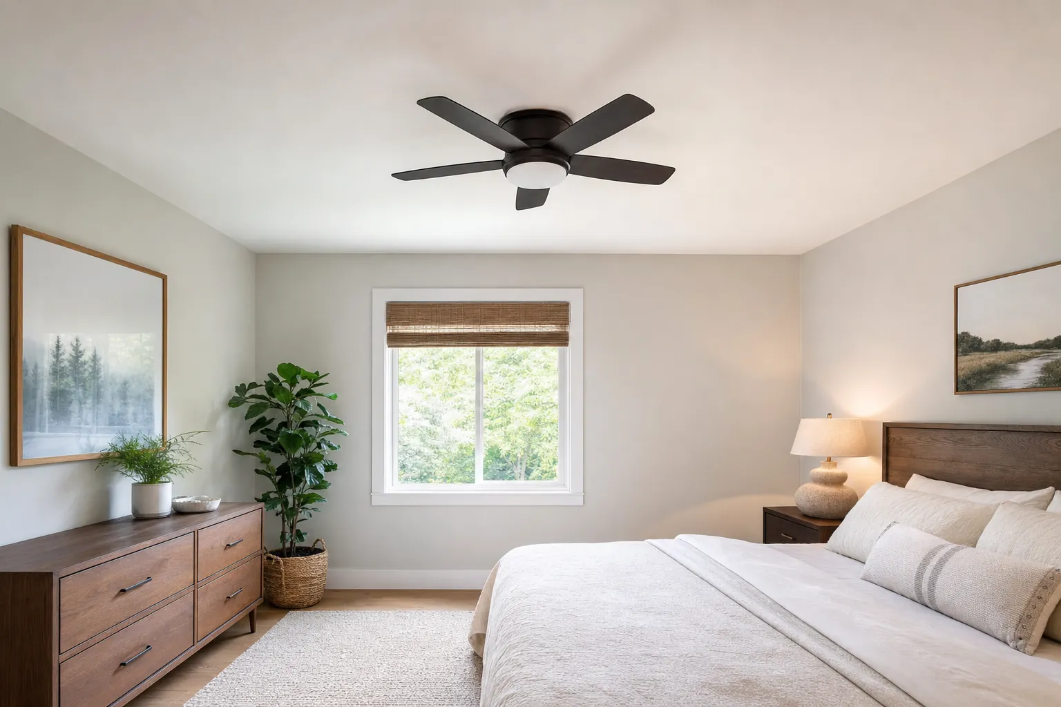 Low-profile ceiling fan installed on the ceiling of a compact bedroom