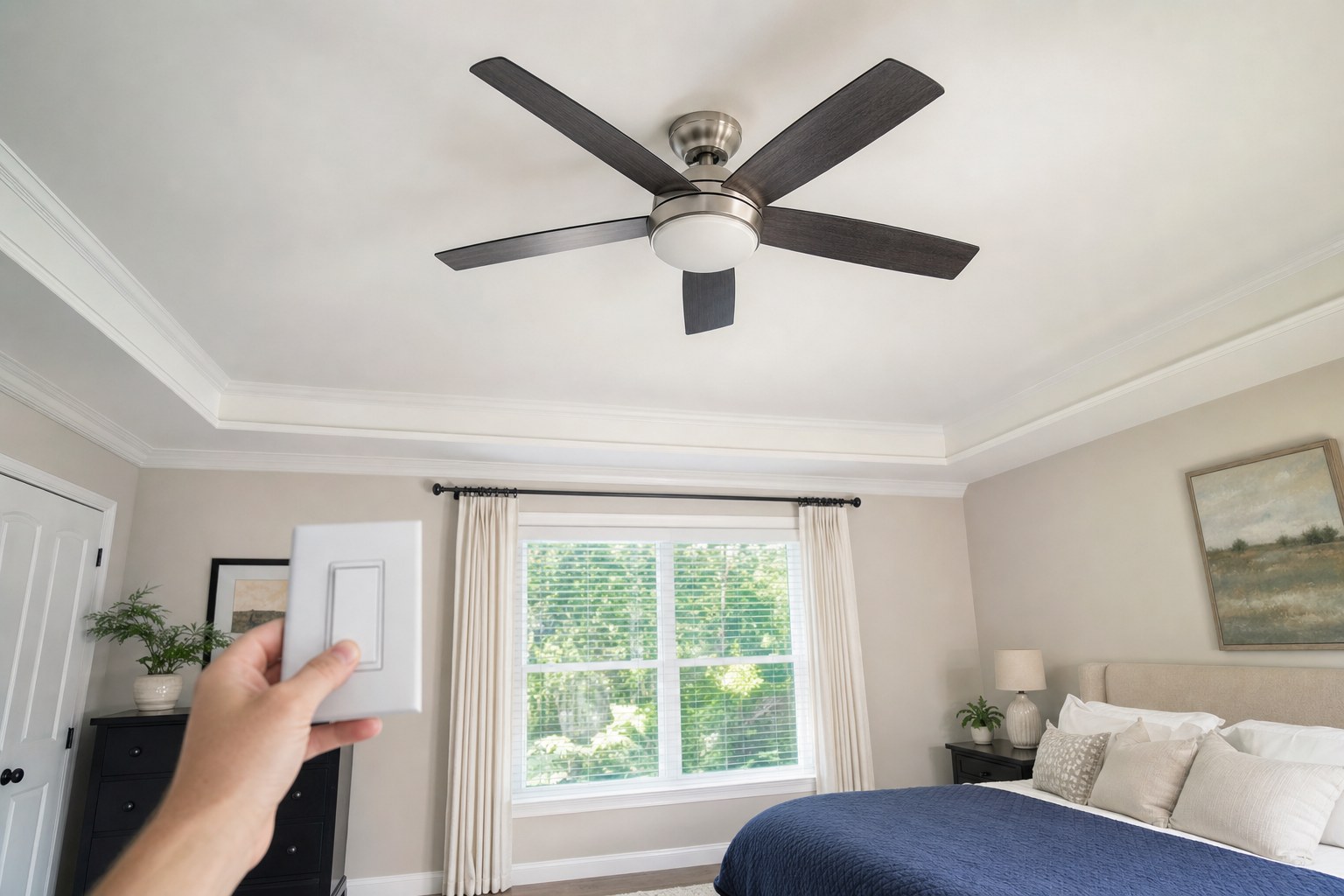 Ceiling fan in a bright bedroom with a wall control in the foreground