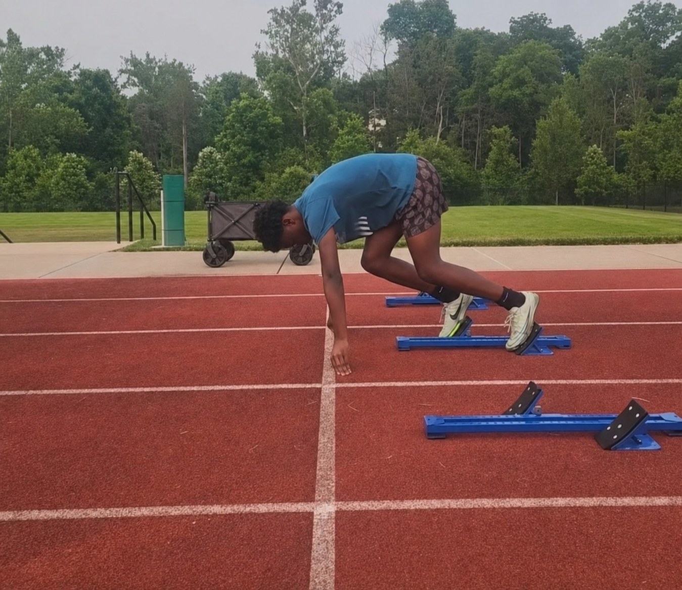 Young athlete practicing a start from blocks during a Virginia Pride track session