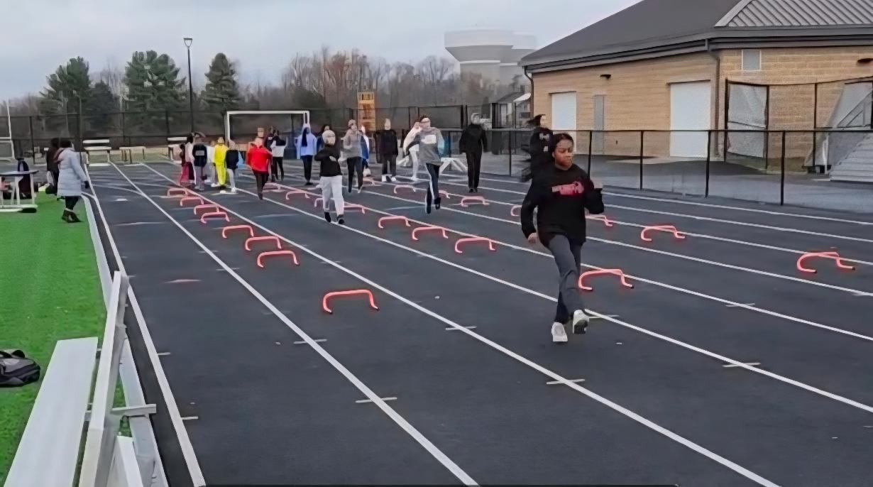 Virginia Pride athletes practicing hurdle drills together on an outdoor track
