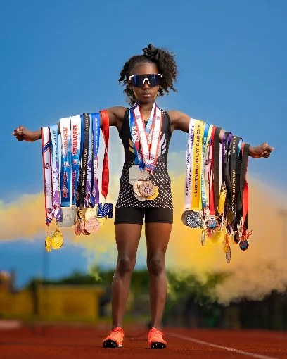 Virginia Pride athlete holding medals on the track
