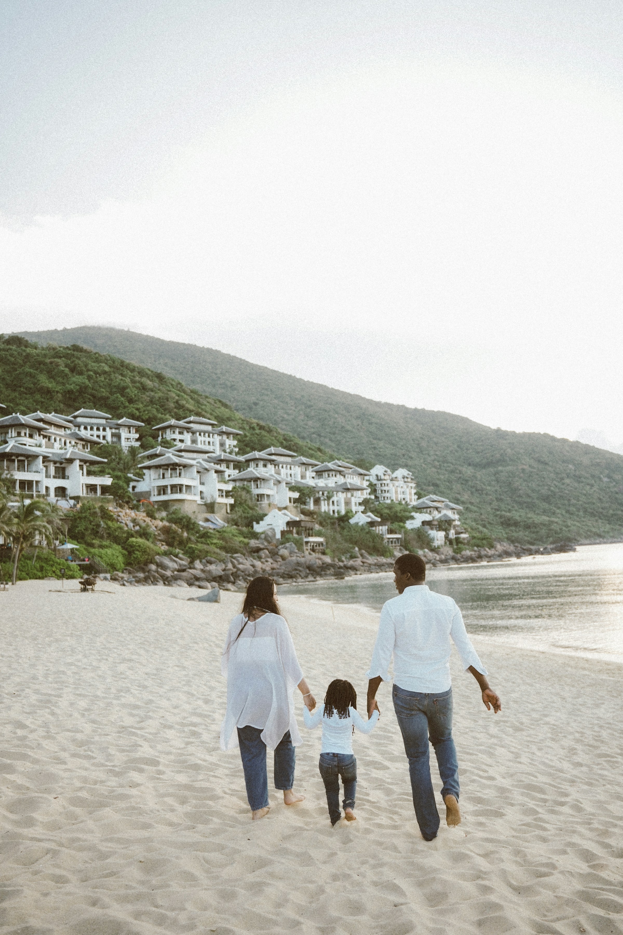 Family walking together along a tropical resort beach